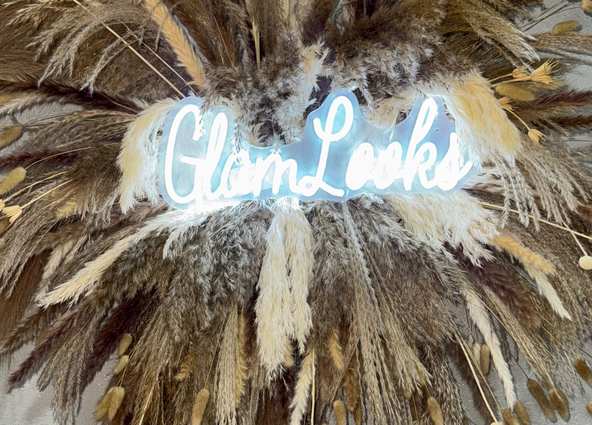 Illuminated Glam Looks sign amid pampas grass at Glam Looks Beauty Salon, Demerara-mahaica, Demerara-mahaica, GY.