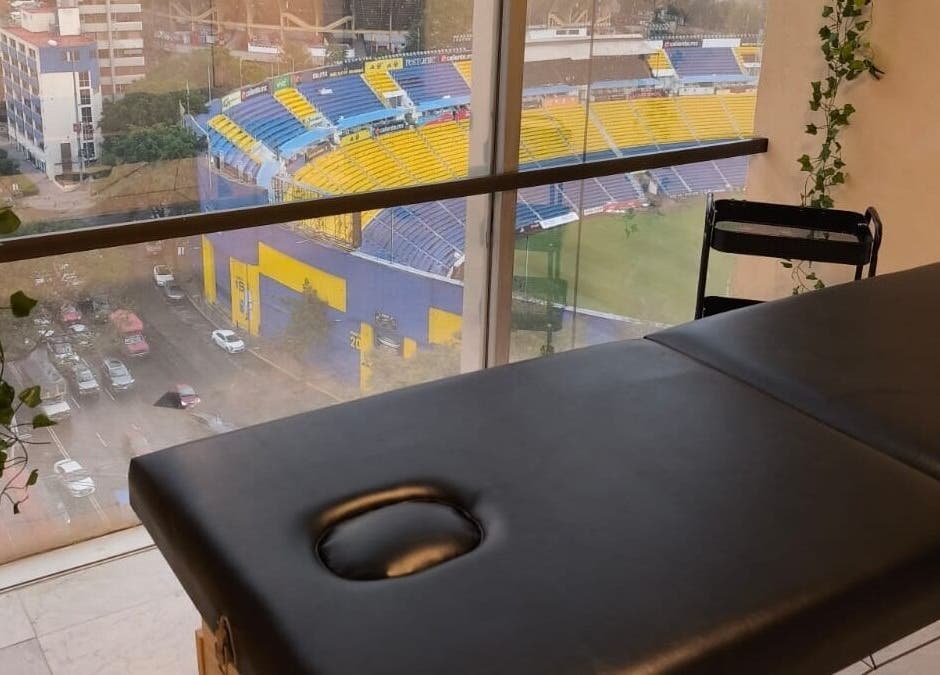 Sala de masajes en Aurea Bienestar Integral, Ciudad De México, con vista al estadio cercano.