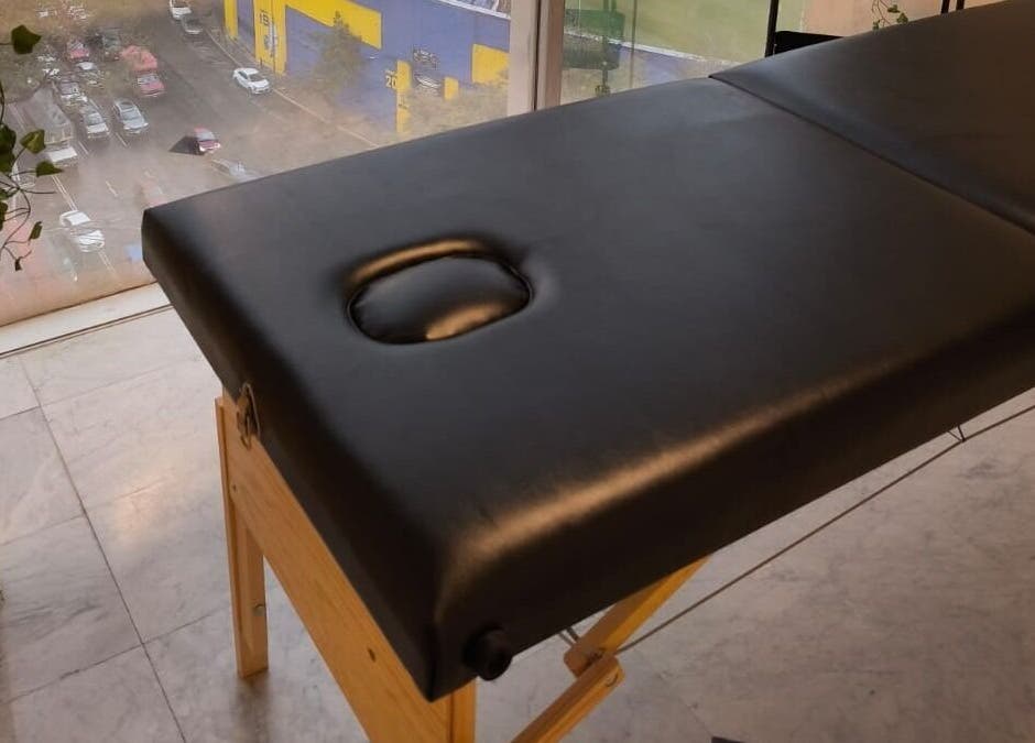 Camilla de masaje en Aurea Bienestar Integral, Ciudad De México, MX, con vista urbana exterior.