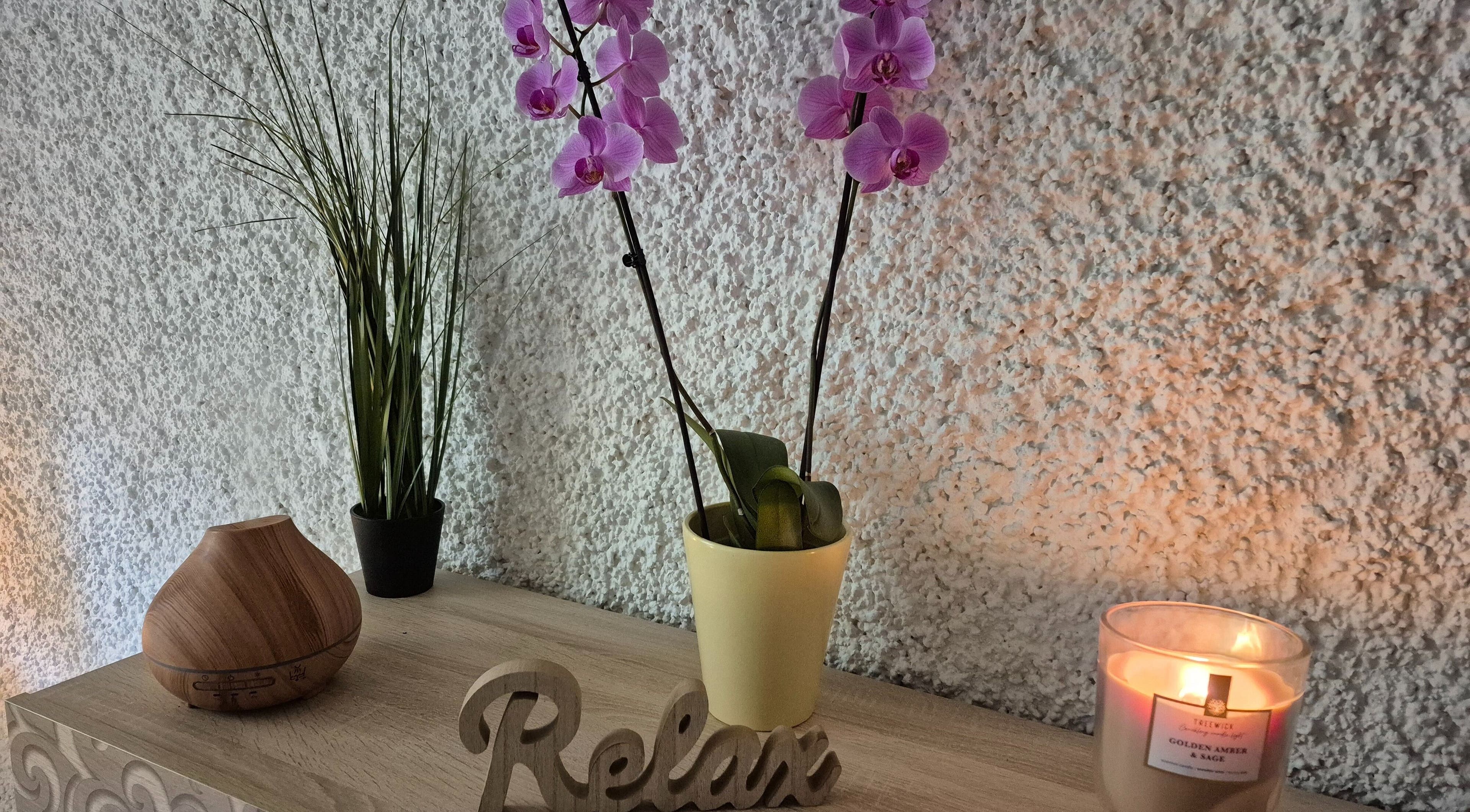 Massagepraxis Aneta in Bern, Bern, CH zeigt eine entspannende Ecke mit Orchidee, Duftkerze und Diffusor.
