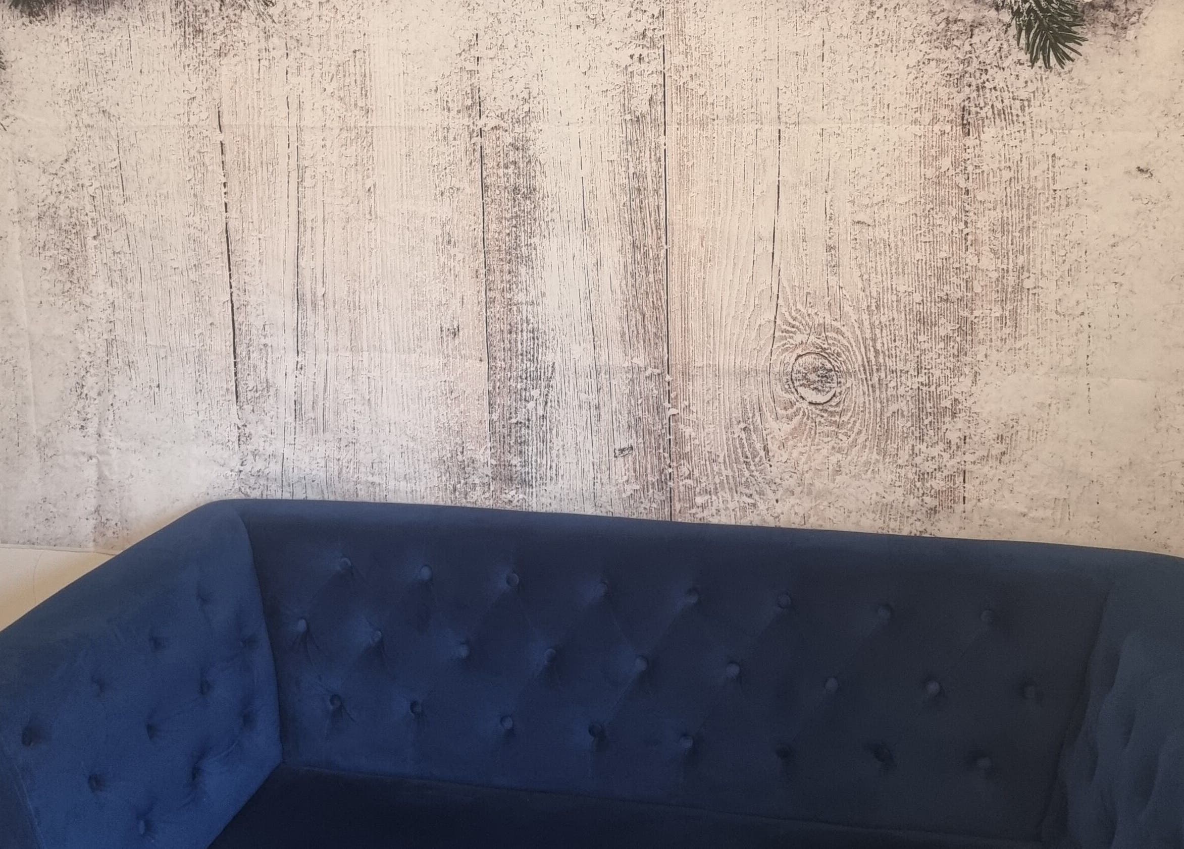 Elegant blue sofa against rustic wall at Hairbysaven#Savenwest, Ipswich, England, GB.