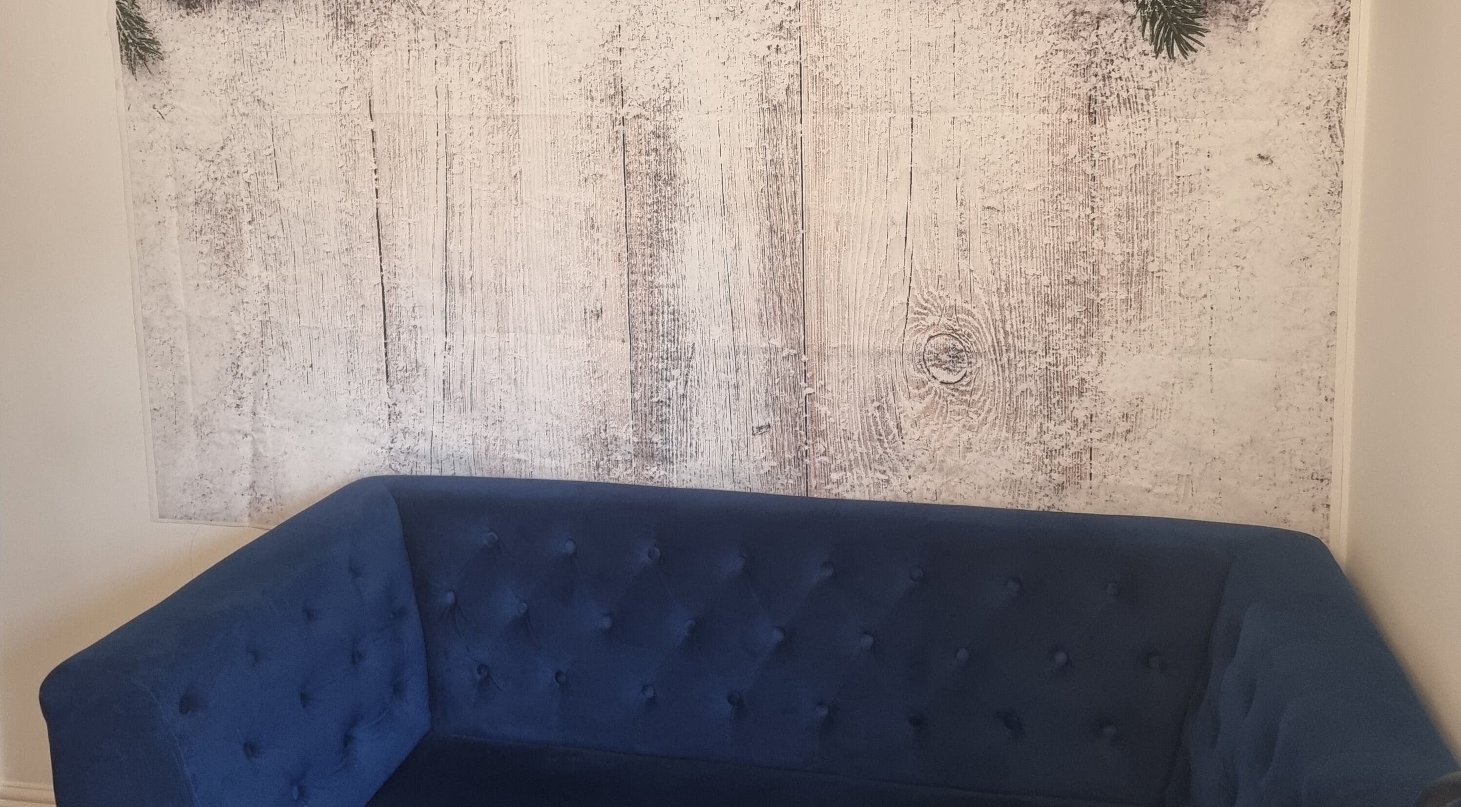 Elegant blue sofa against rustic wall at Hairbysaven#Savenwest, Ipswich, England, GB.