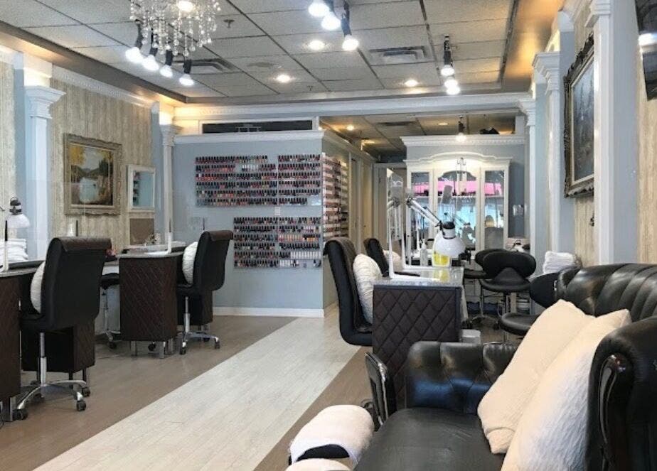 Interior of Magnifique Nail Spa, Vancouver, BC, CA featuring stylish seating and nail stations.