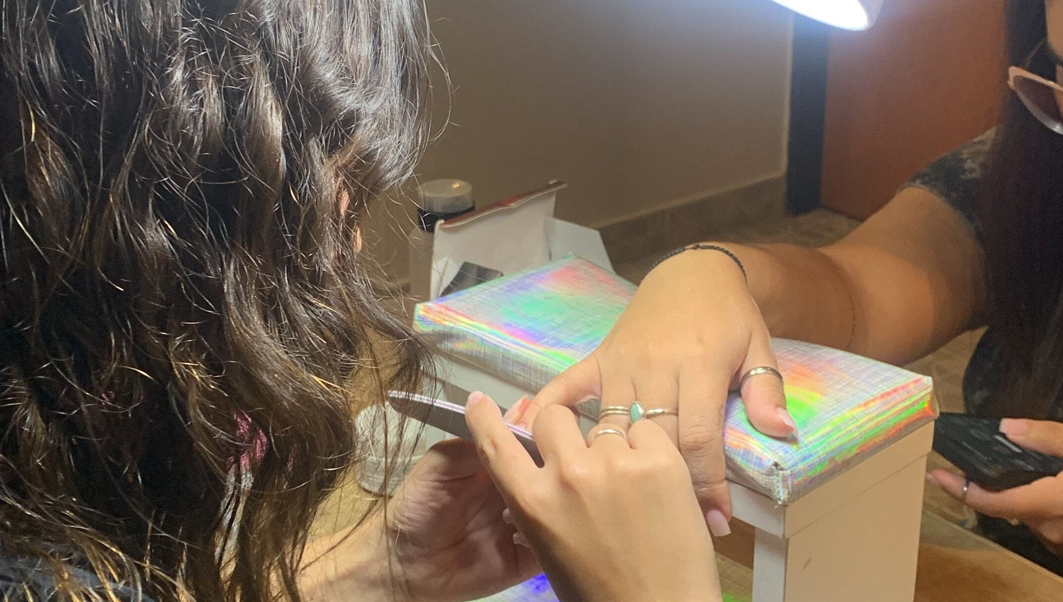 Mujer recibiendo manicura en CM Braids, Tapiales, Provincia De Buenos Aires, AR.