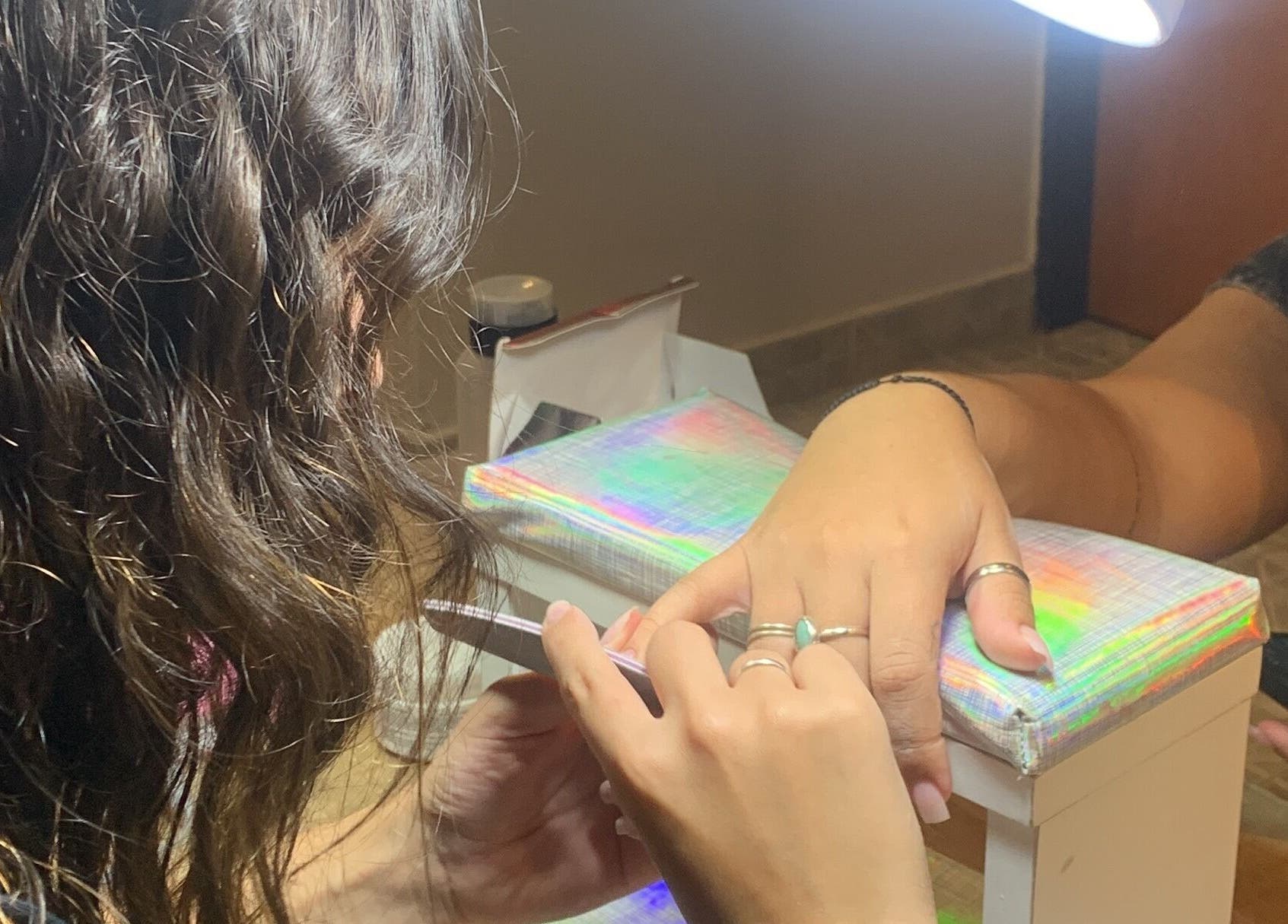 Mujer recibiendo manicura en CM Braids, Tapiales, Provincia De Buenos Aires, AR.
