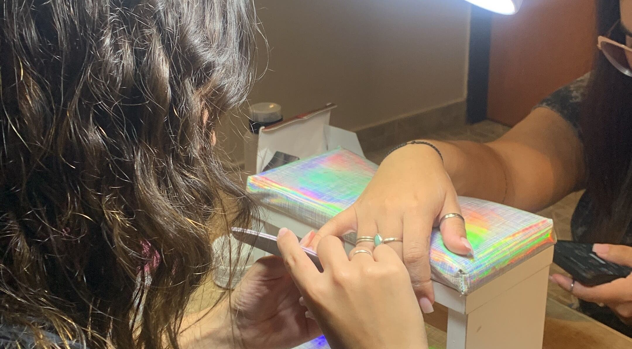 Mujer recibiendo manicura en CM Braids, Tapiales, Provincia De Buenos Aires, AR.
