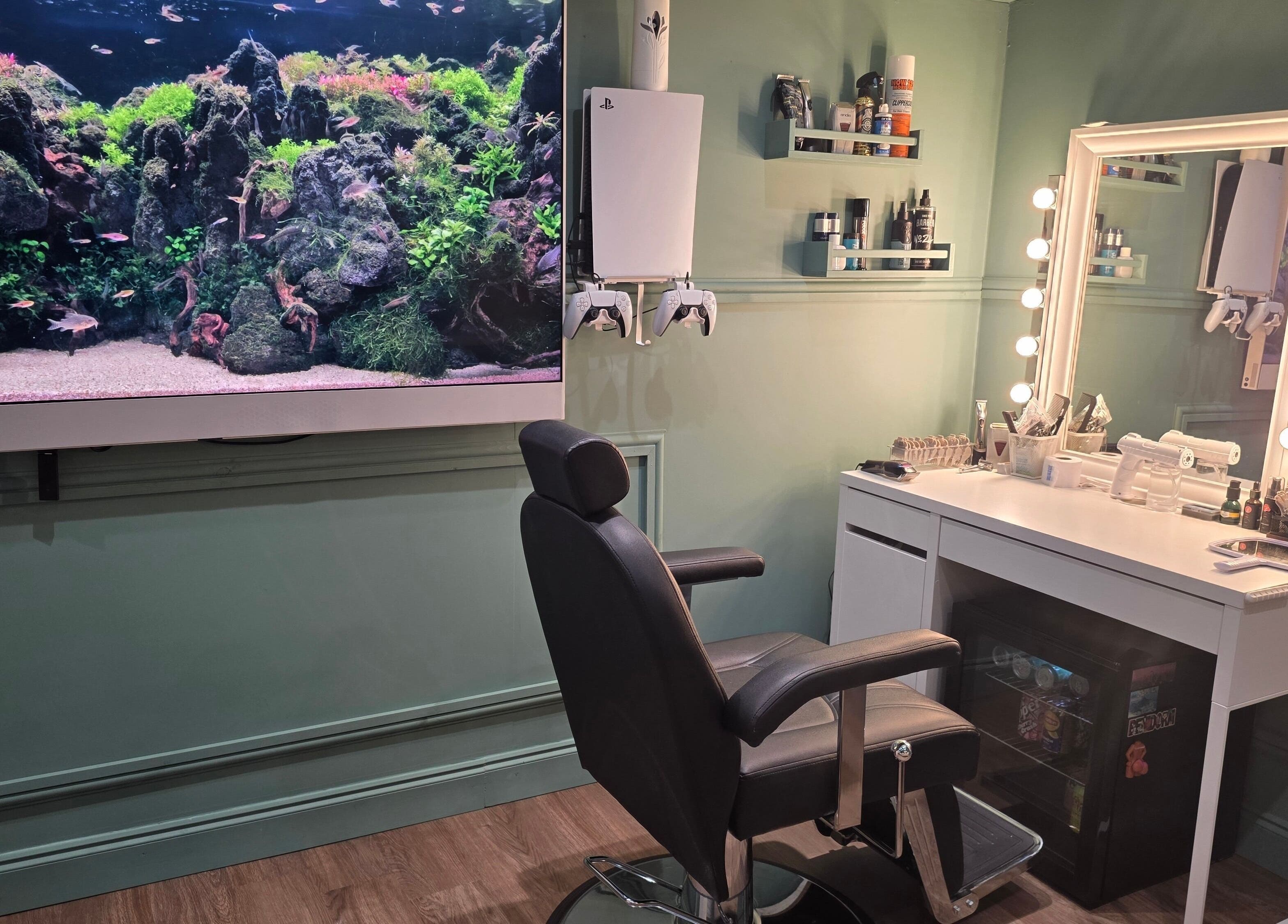 Modern barber station with illuminated mirror and fish tank at The Green Room Barbers, Leeds, England, GB.