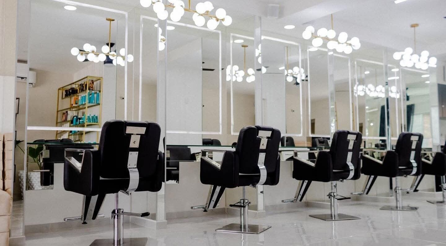 Interior elegante de Jesús Luna @GlamHouse en Puerto Vallarta, MX con sillas de peluquería modernas.