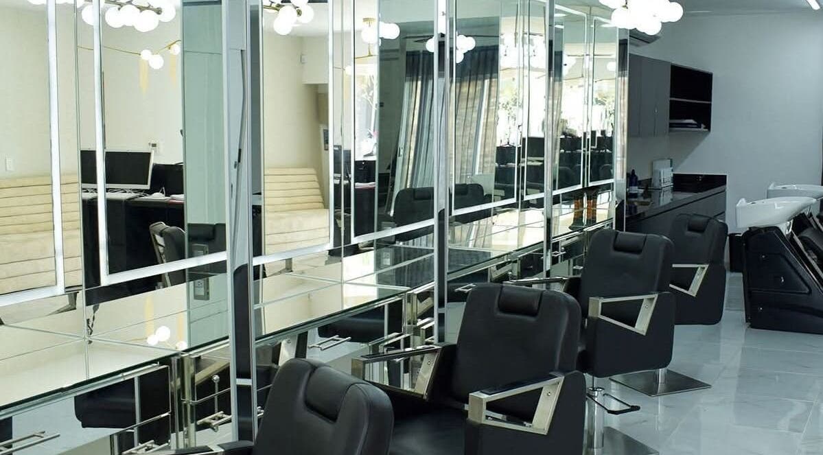 Área de peluquería elegante en Jesús Luna @GlamHouse, Puerto Vallarta, MX, con sillas modernas y espejos amplios.