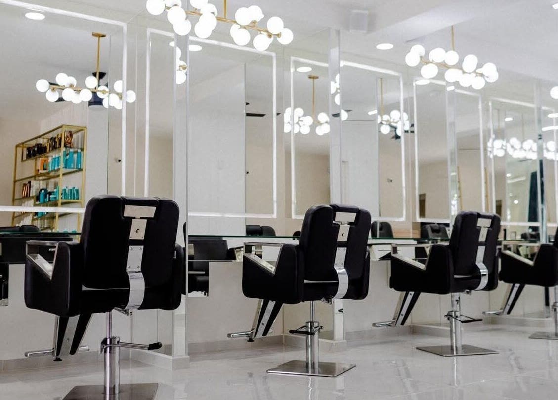 Salón moderno en Jesús Luna GlamHouse, Puerto Vallarta, Jalisco, MX, con sillas y espejos elegantes.