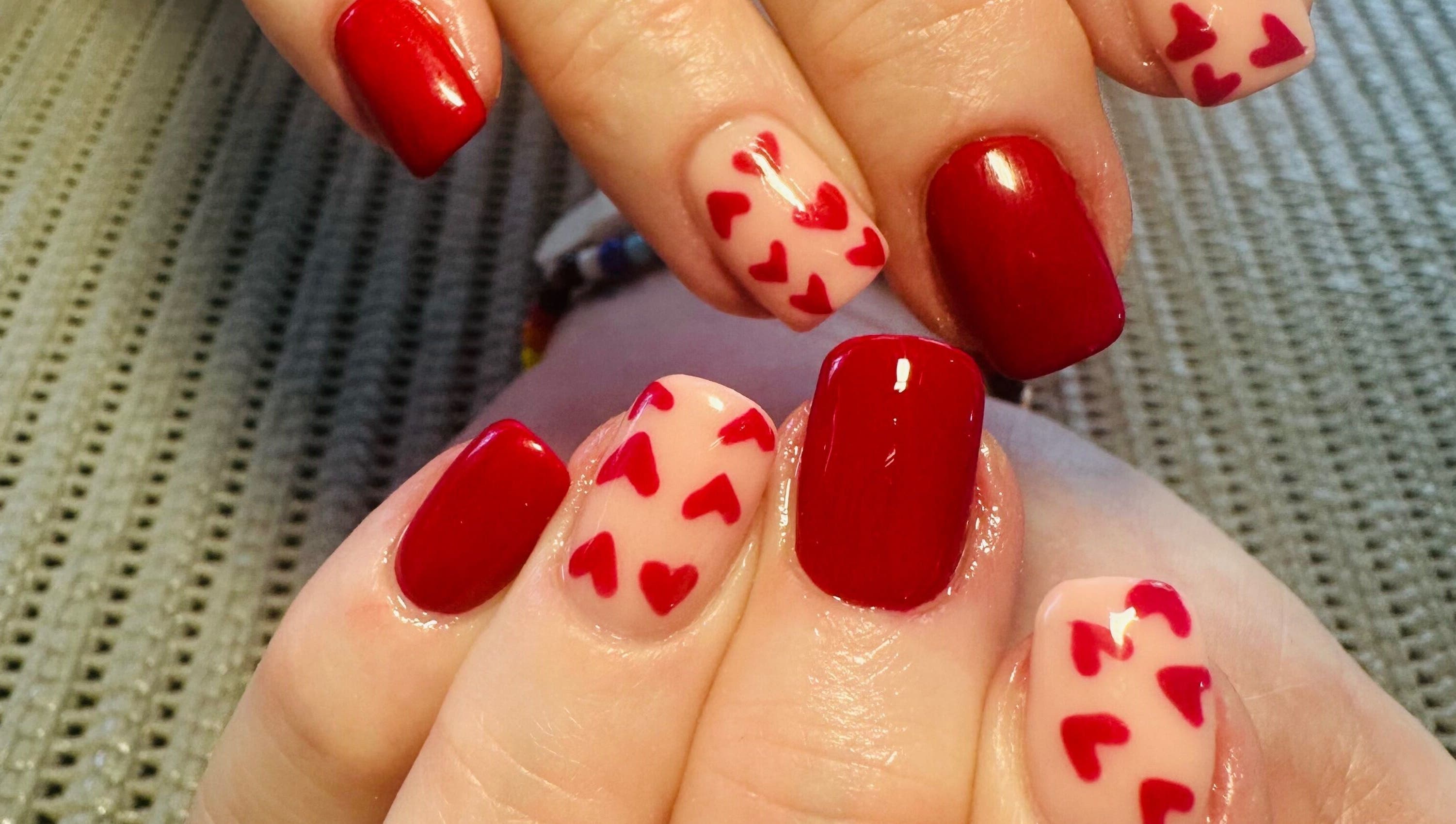 Elegant red and heart-accented nails at Lux-glomournails, Cape Town, Western Cape, ZA.