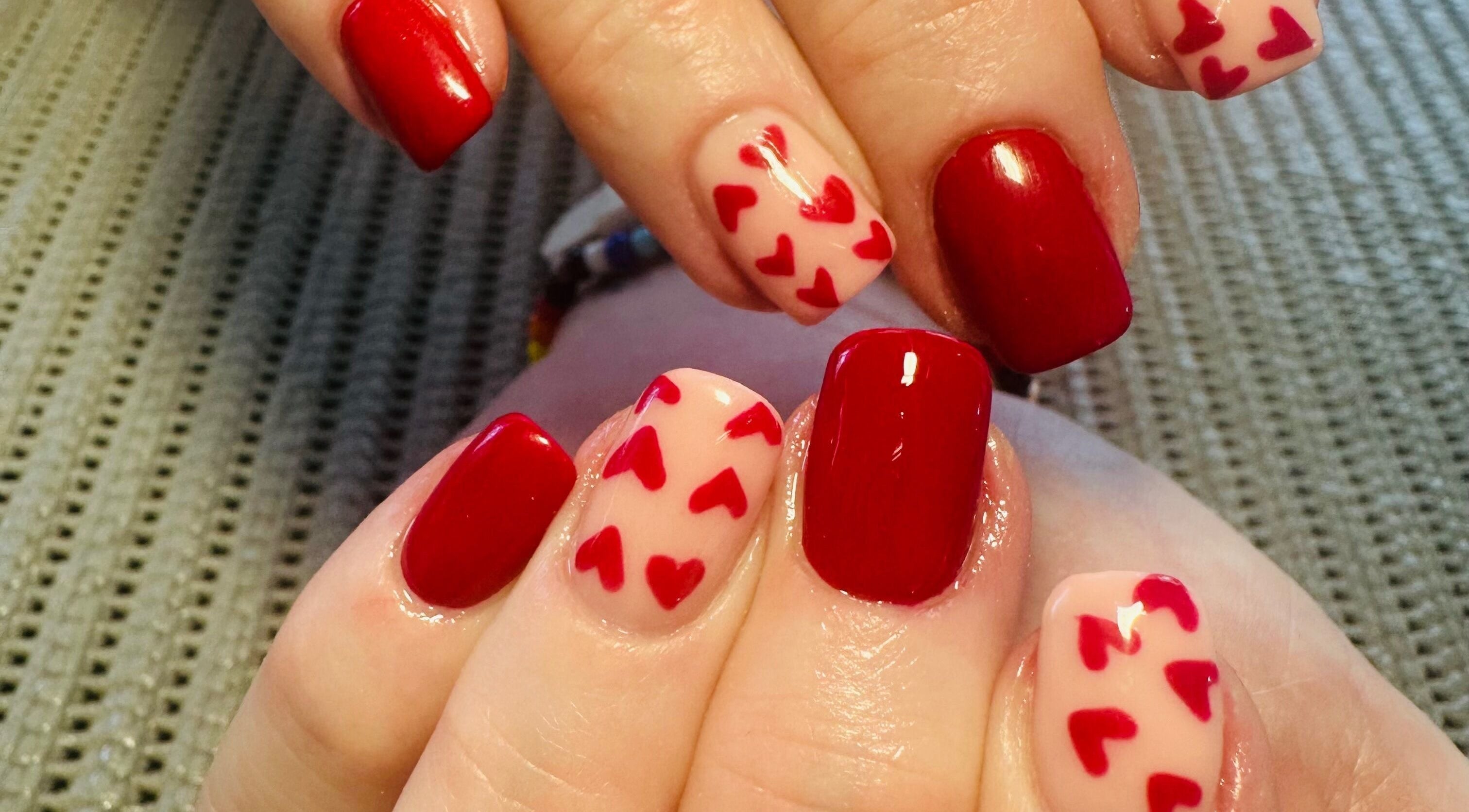 Elegant red and heart-accented nails at Lux-glomournails, Cape Town, Western Cape, ZA.