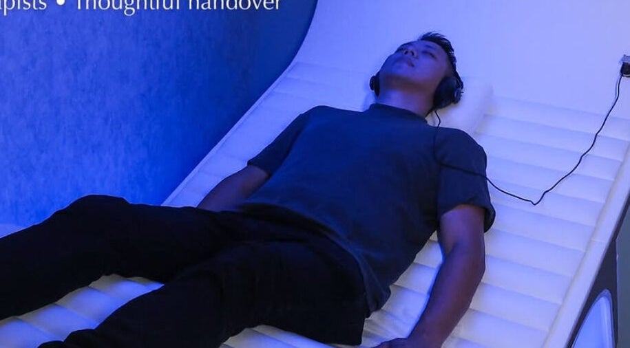 Person relaxing in a futuristic pod at Be Earth Wellness, Hong Kong Island, HK.