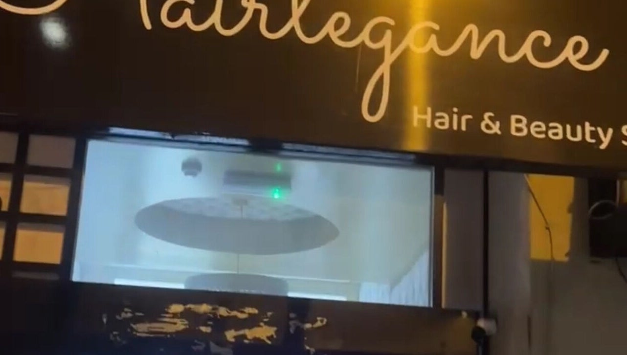 Hairlegance sign at night in Newcastle upon Tyne, England, GB gleaming with soft light.