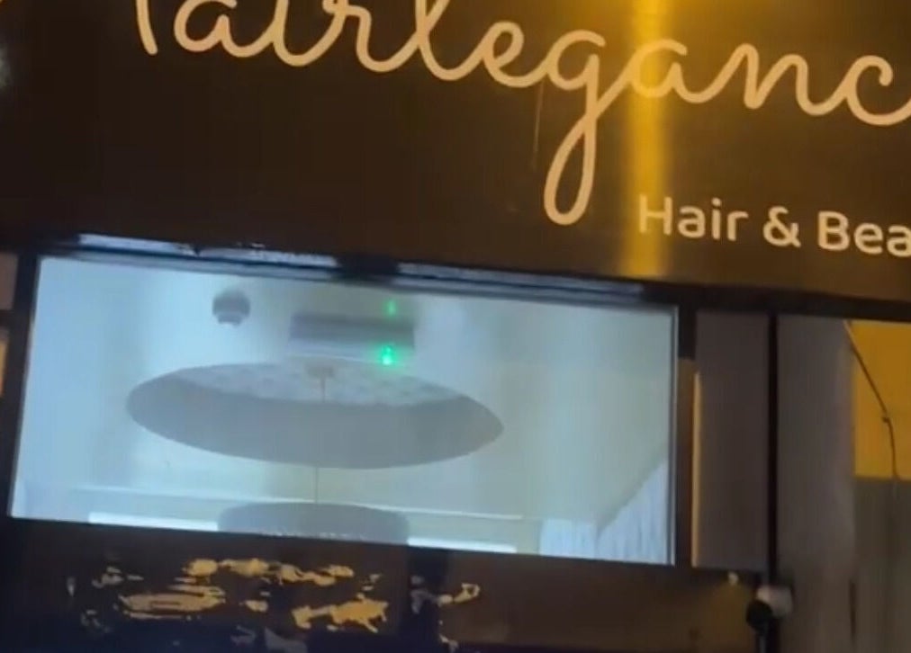 Hairlegance sign at night in Newcastle upon Tyne, England, GB gleaming with soft light.