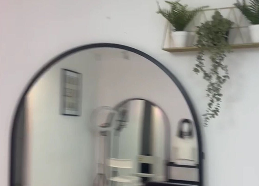 Stylish salon interior at Hairlegance, Newcastle upon Tyne, England, with mirror and greenery decor.