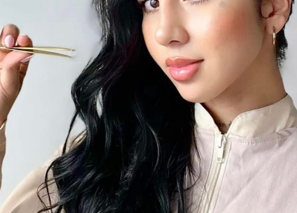 Mujer sosteniendo pinzas en Latín Beauty, Cap Martinet, Illes Balears, ES, mostrando precisión en belleza.