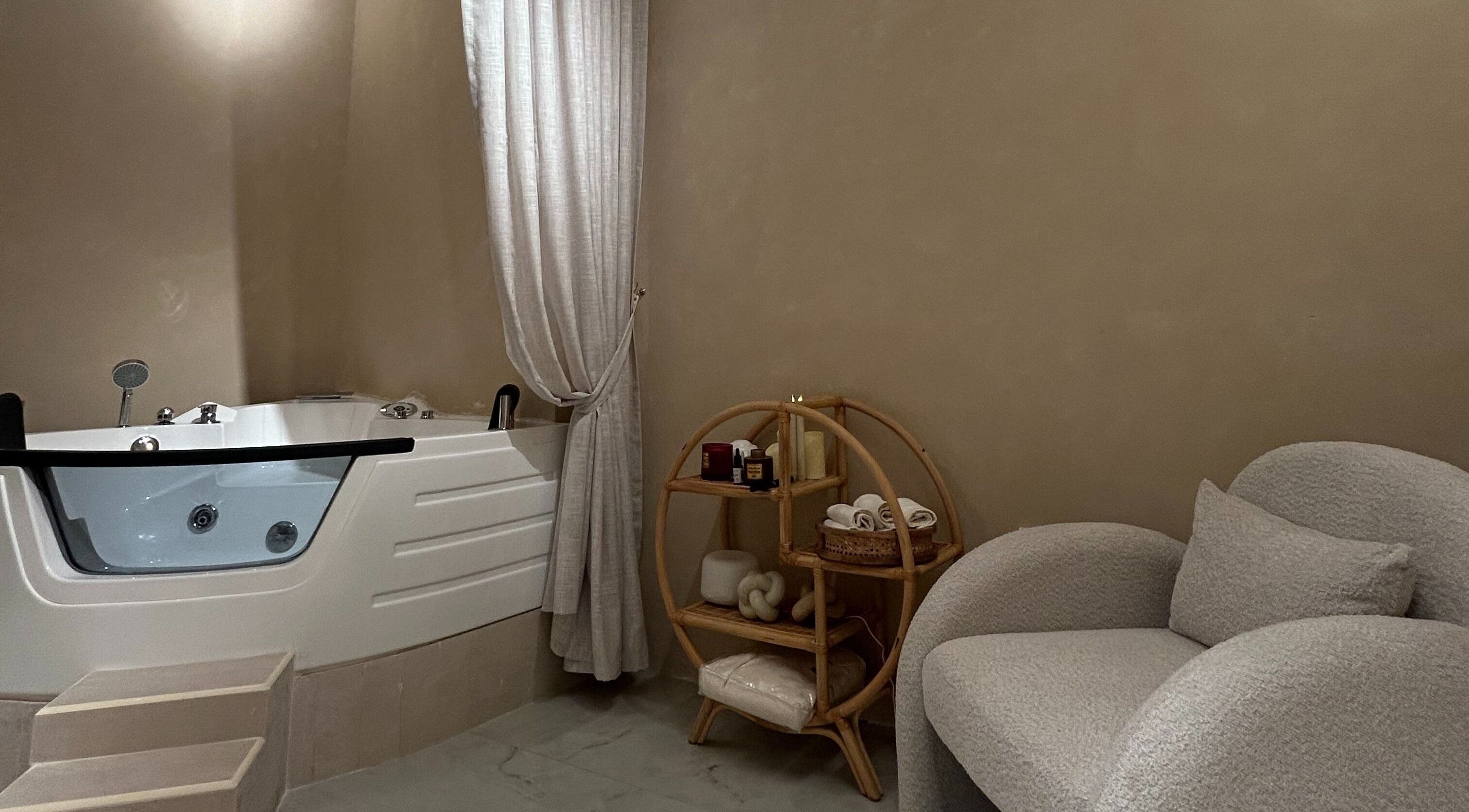 Relaxing spa room with tub and cozy chair at Al Kadi Beauty Centre Salon & Spa, Sharjah, Sharjah, AE.