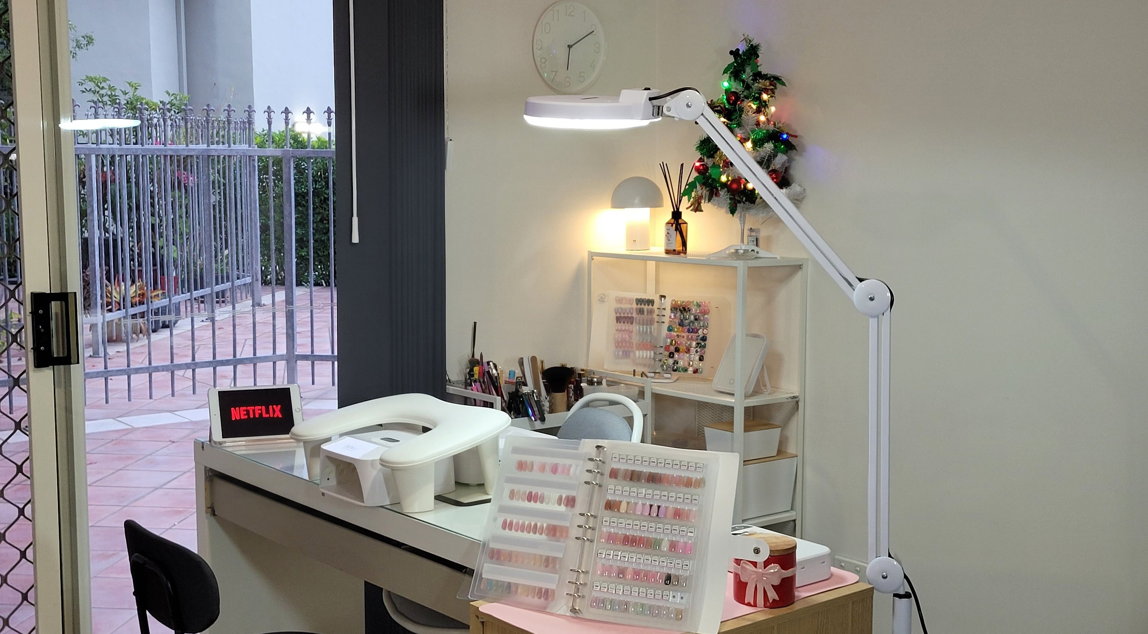 Cozy nail station at Natural Hues in Yeronga, Queensland, AU, with vibrant nail polish display and ambient lighting.