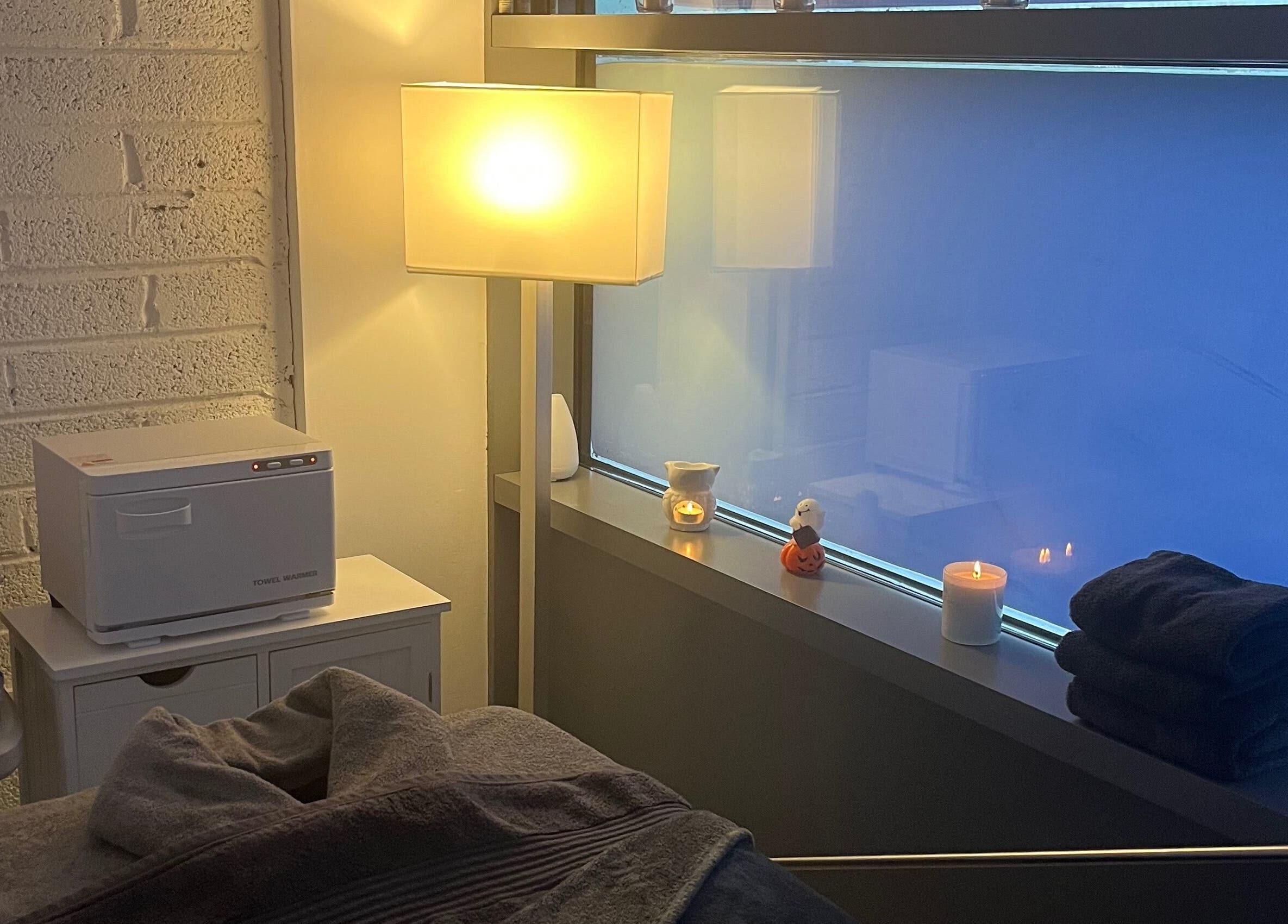 Тёплая атмосфера TK Massage Therapy в County Wicklow, IE с уютным освещением и мягкими полотенцами.