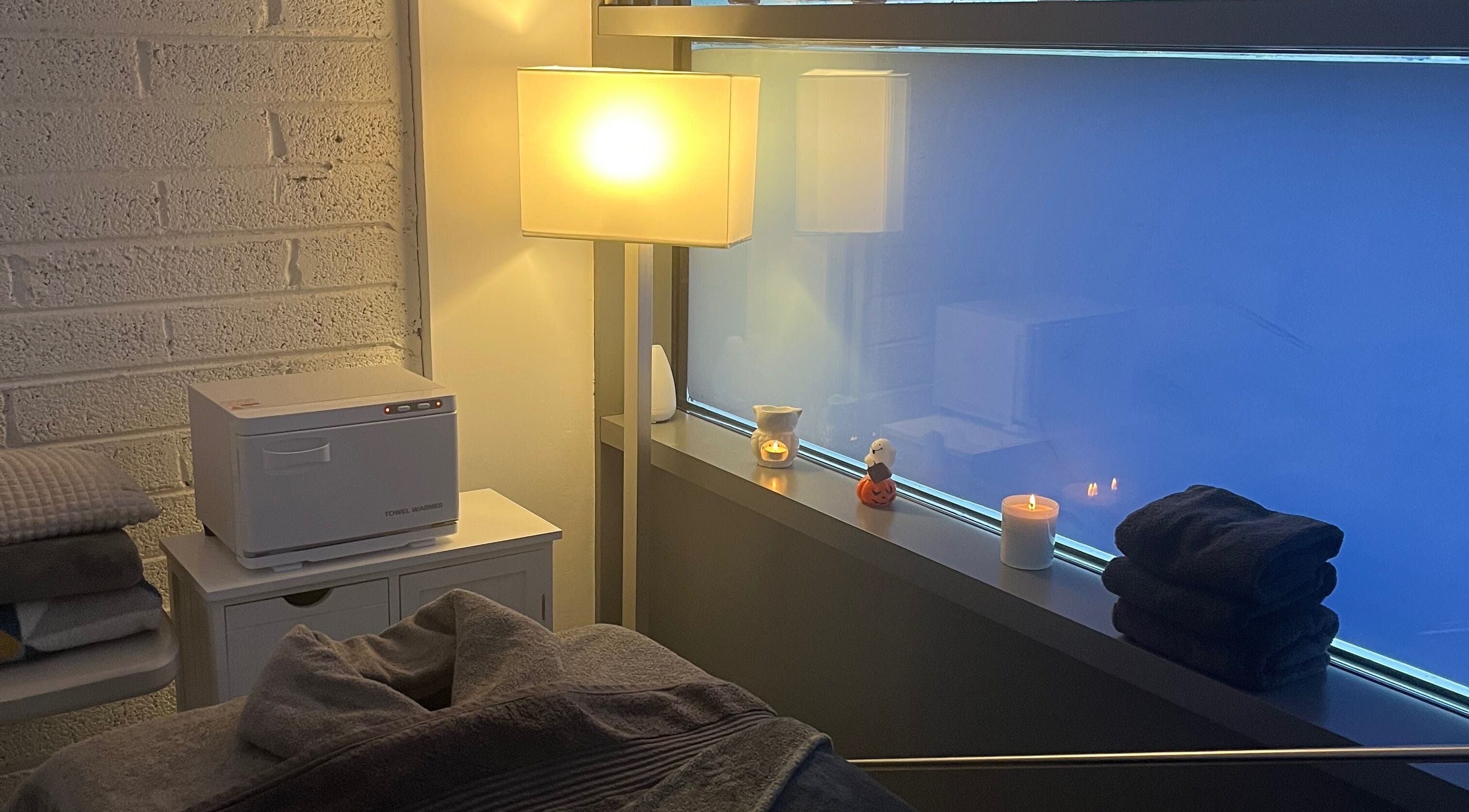 Тёплая атмосфера TK Massage Therapy в County Wicklow, IE с уютным освещением и мягкими полотенцами.