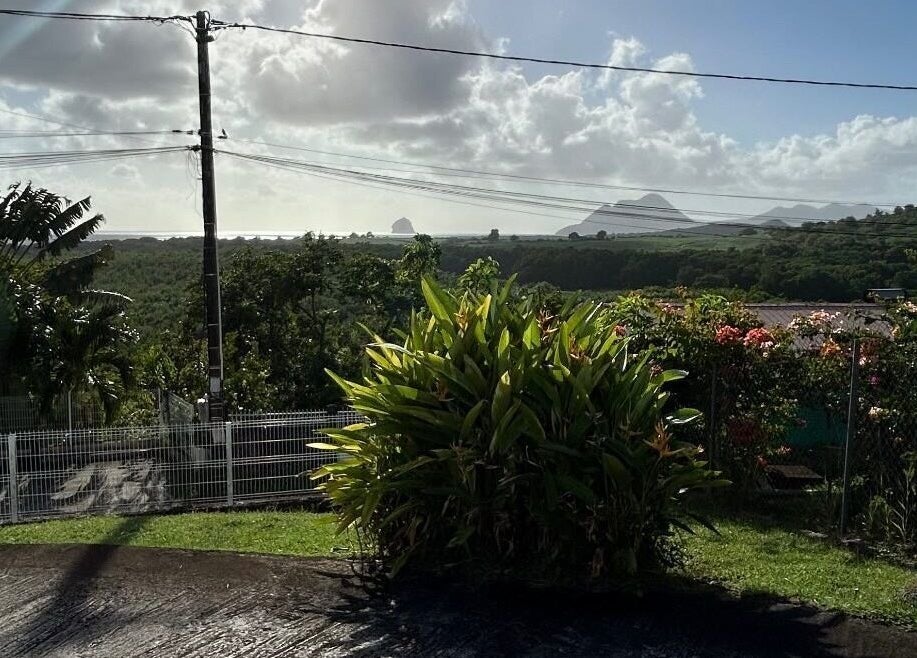 Vue panoramique depuis Éclat Créole offrant un paysage tropical à Sainte-Luce, MQ sous un ciel lumineux.