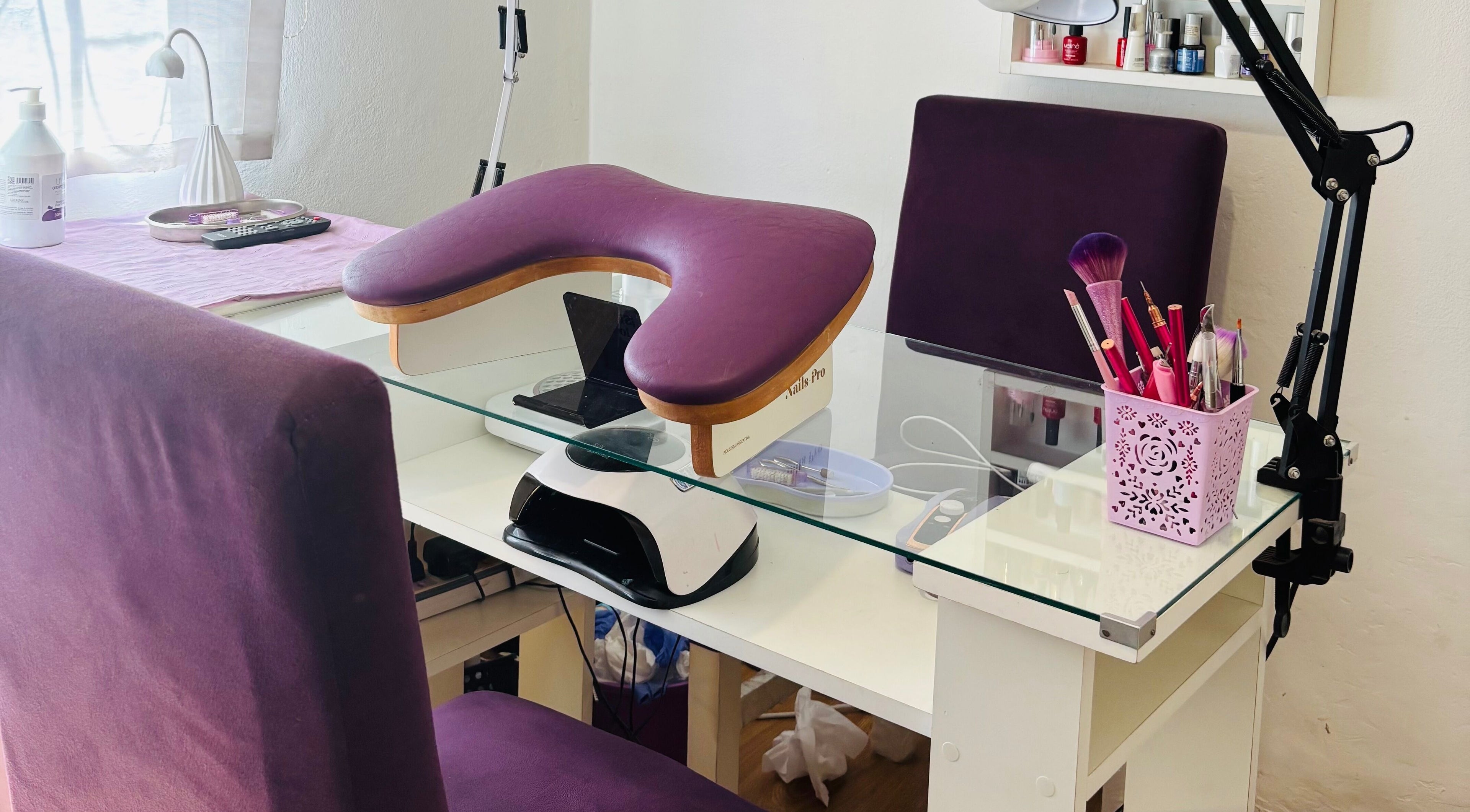 Estación de uñas en Aura nails, Villa Ballester, Buenos Aires. Mesa blanca con asiento púrpura y herramientas de manicura.