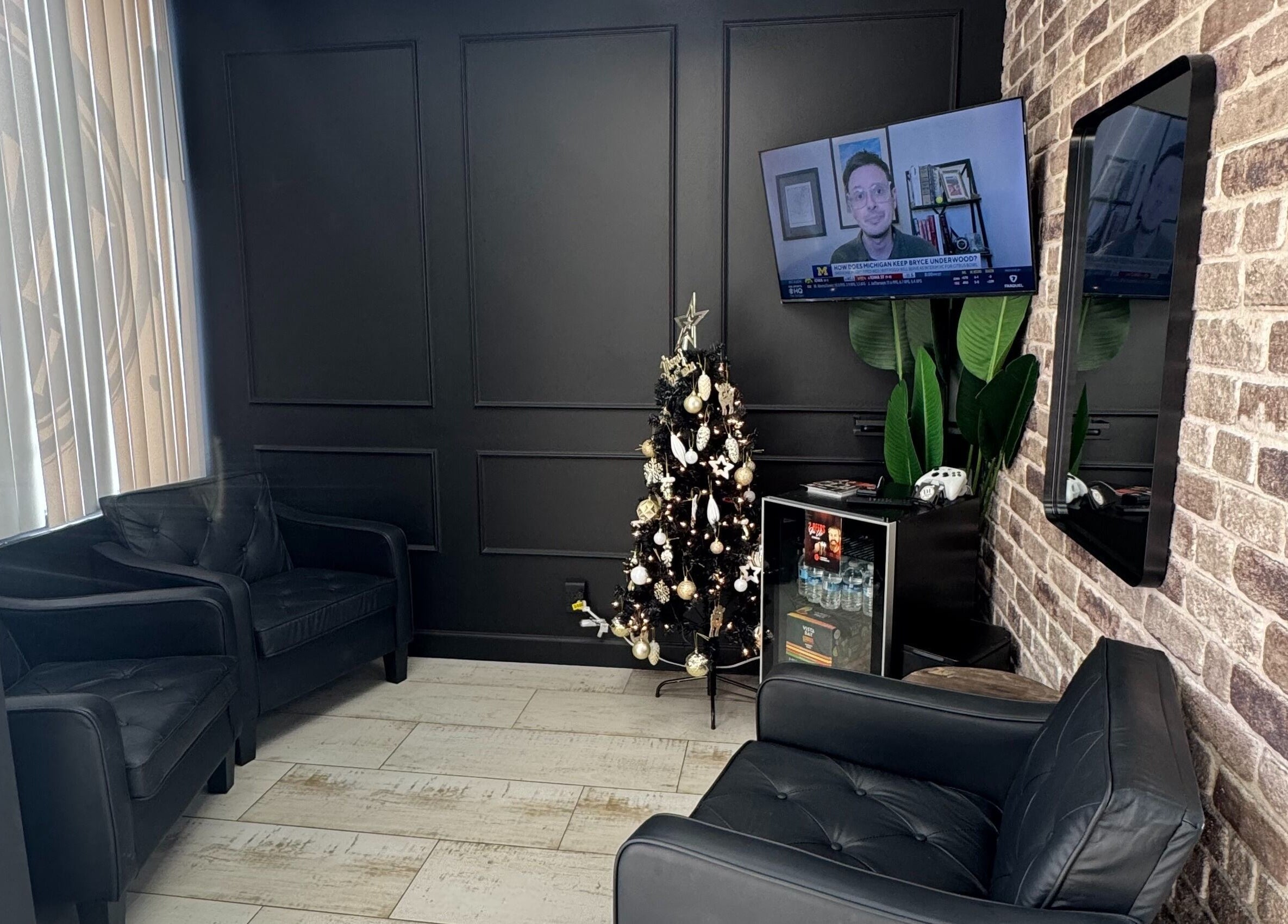 Inviting lounge area at Hair Lab Studio Salon, Fort Lauderdale, FL, US with sleek black seating and a festive tree.