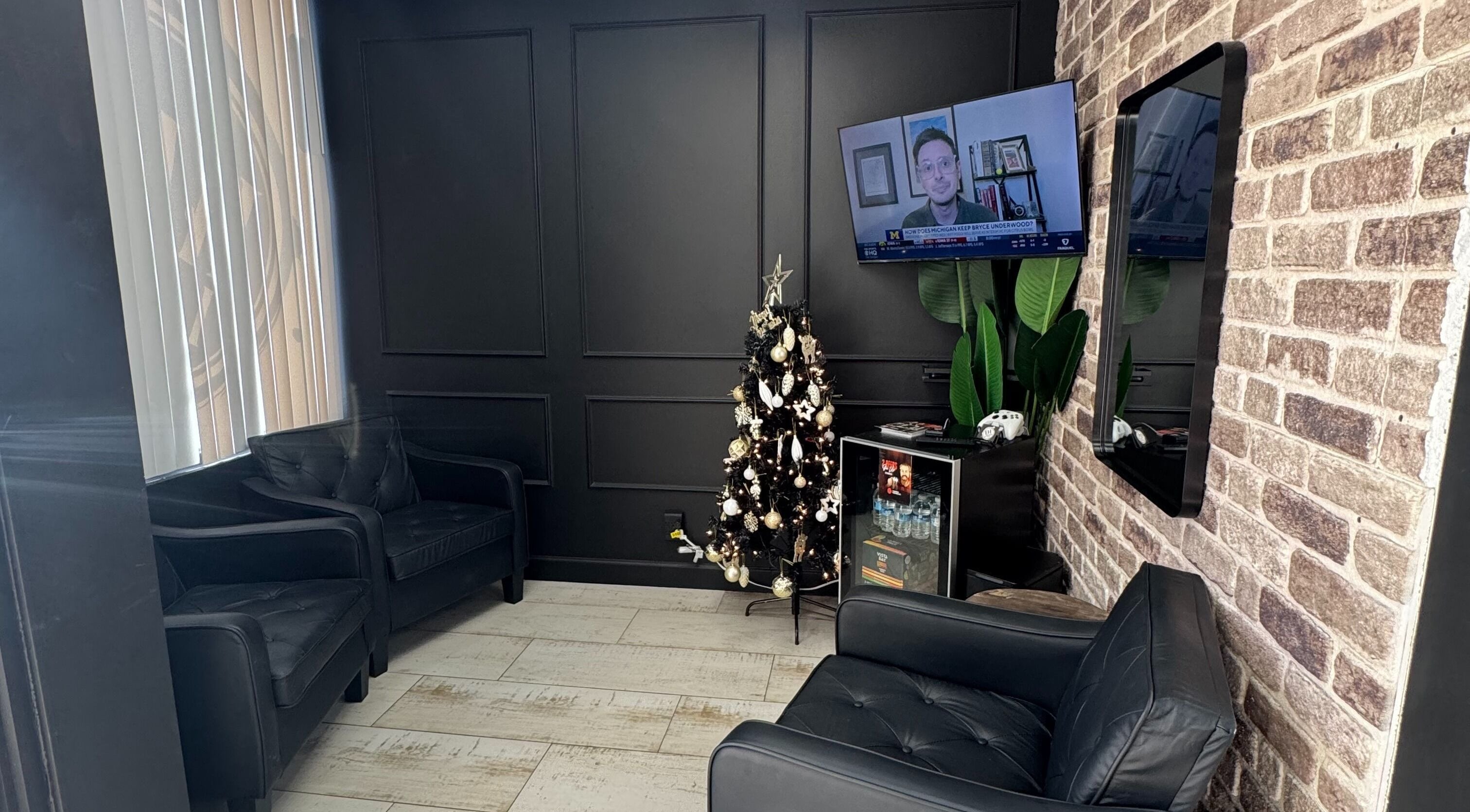 Inviting lounge area at Hair Lab Studio Salon, Fort Lauderdale, FL, US with sleek black seating and a festive tree.