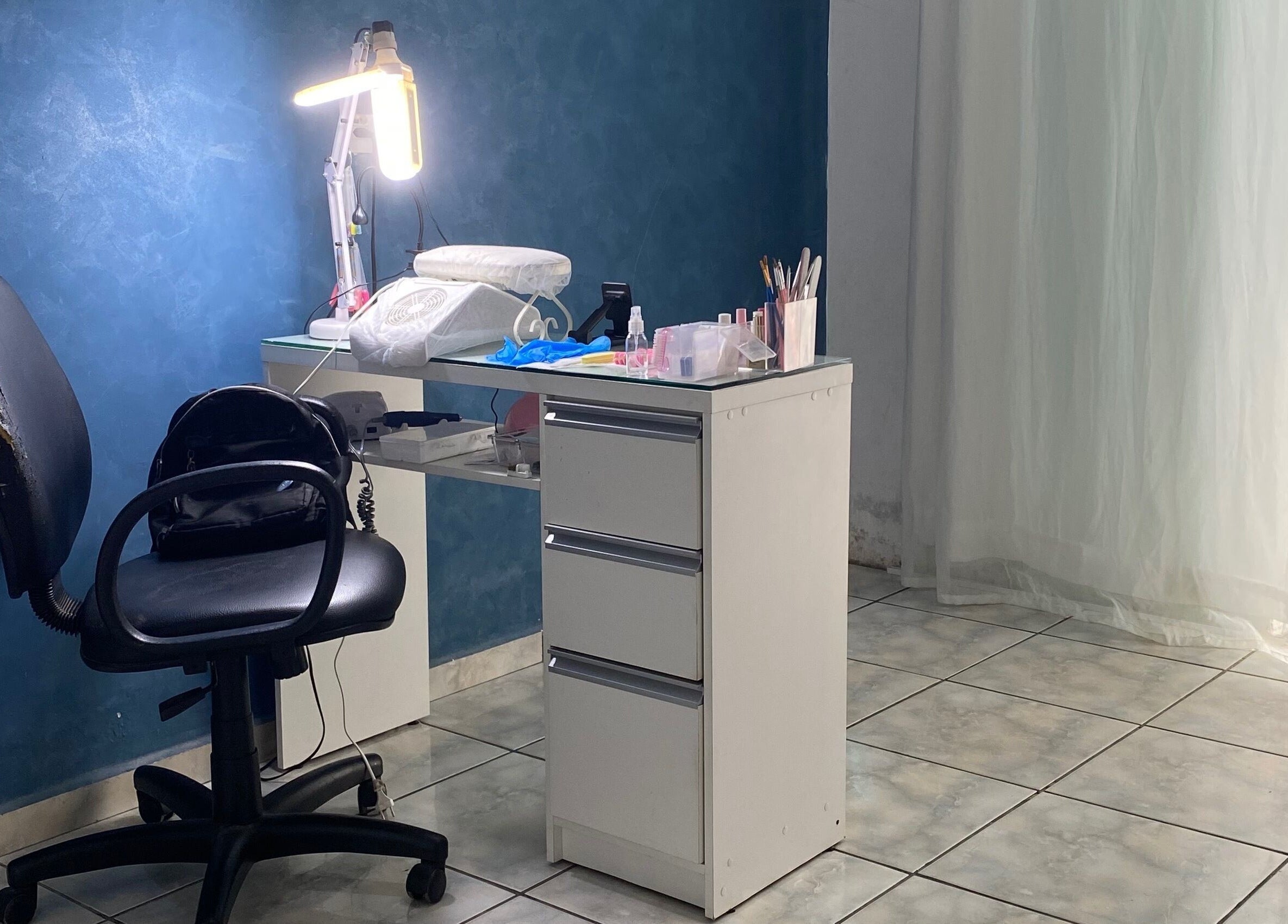 Estação de trabalho na Lucia Correia Nail Design, Paraná, PR, BR, com cadeira e mesa organizada.