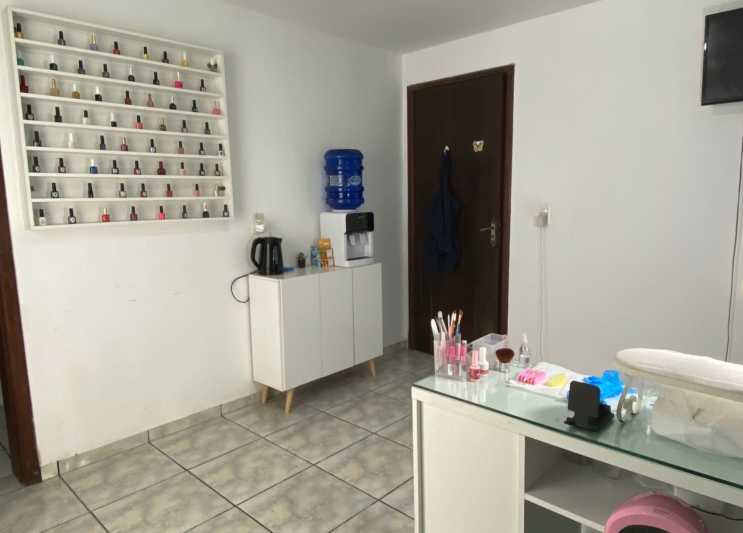 Sala de manicure da Lucia Correia Nail Design em Paraná, Paraná, BR, com esmaltes e mesa preparados.