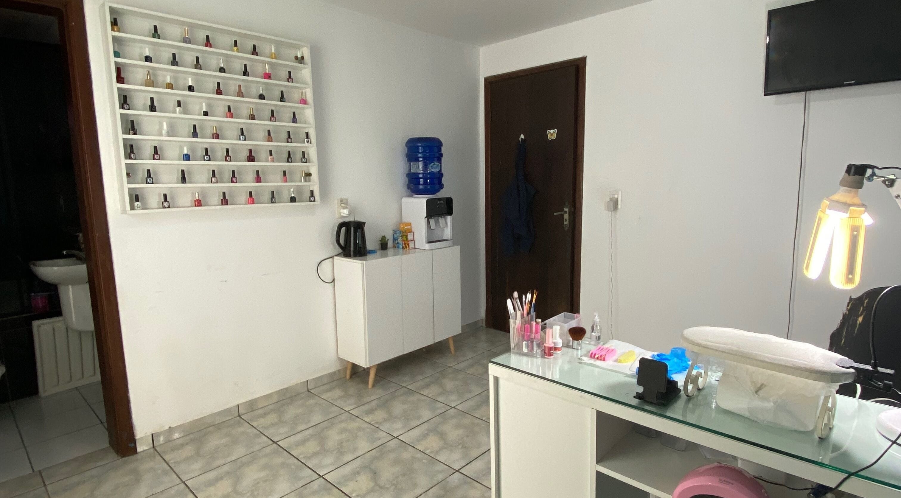 Sala de manicure da Lucia Correia Nail Design em Paraná, Paraná, BR, com esmaltes e mesa preparados.