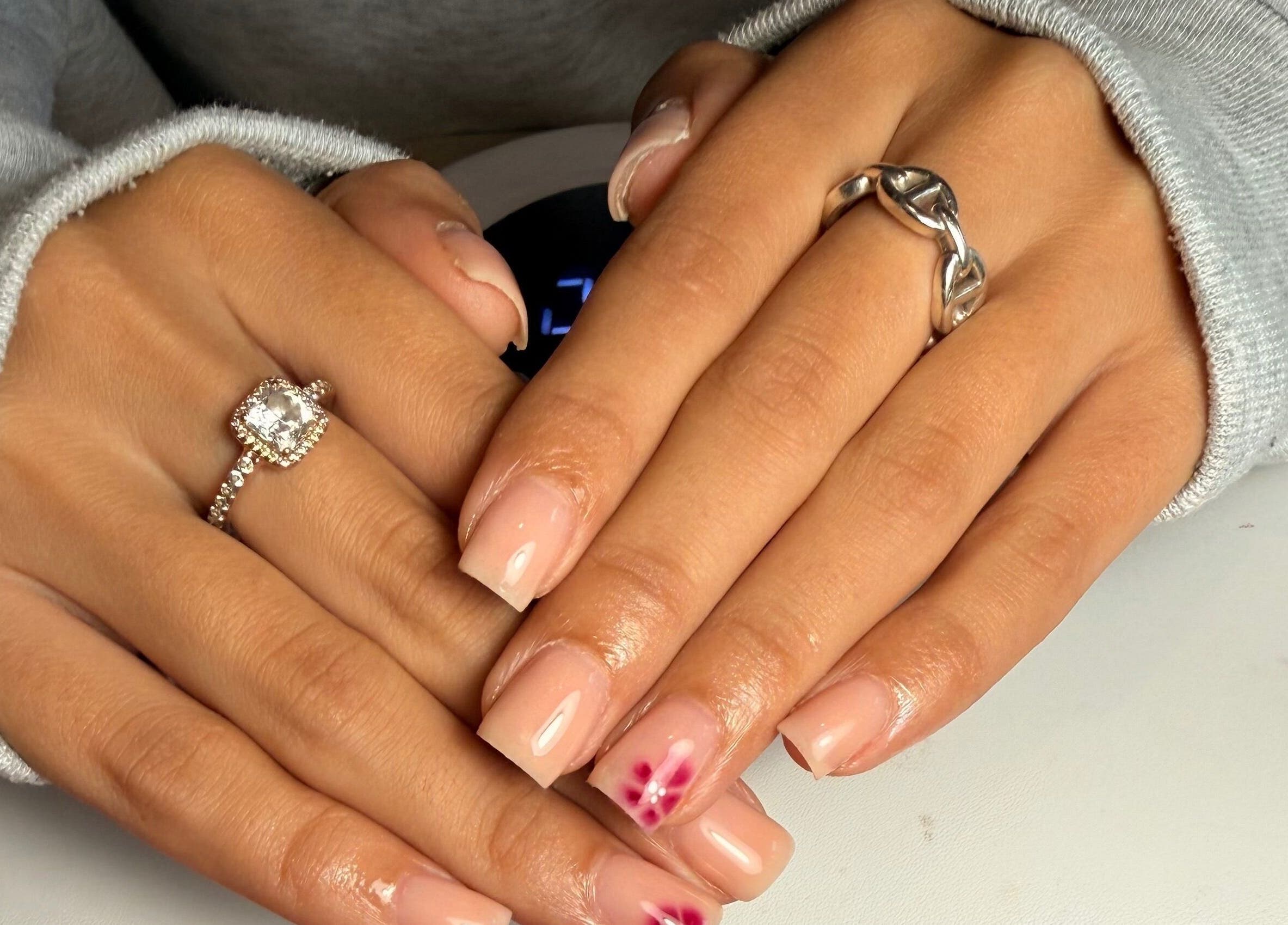 Manicured hands with pink floral design at naileditbyjadee, Barnoldswick, England, GB.