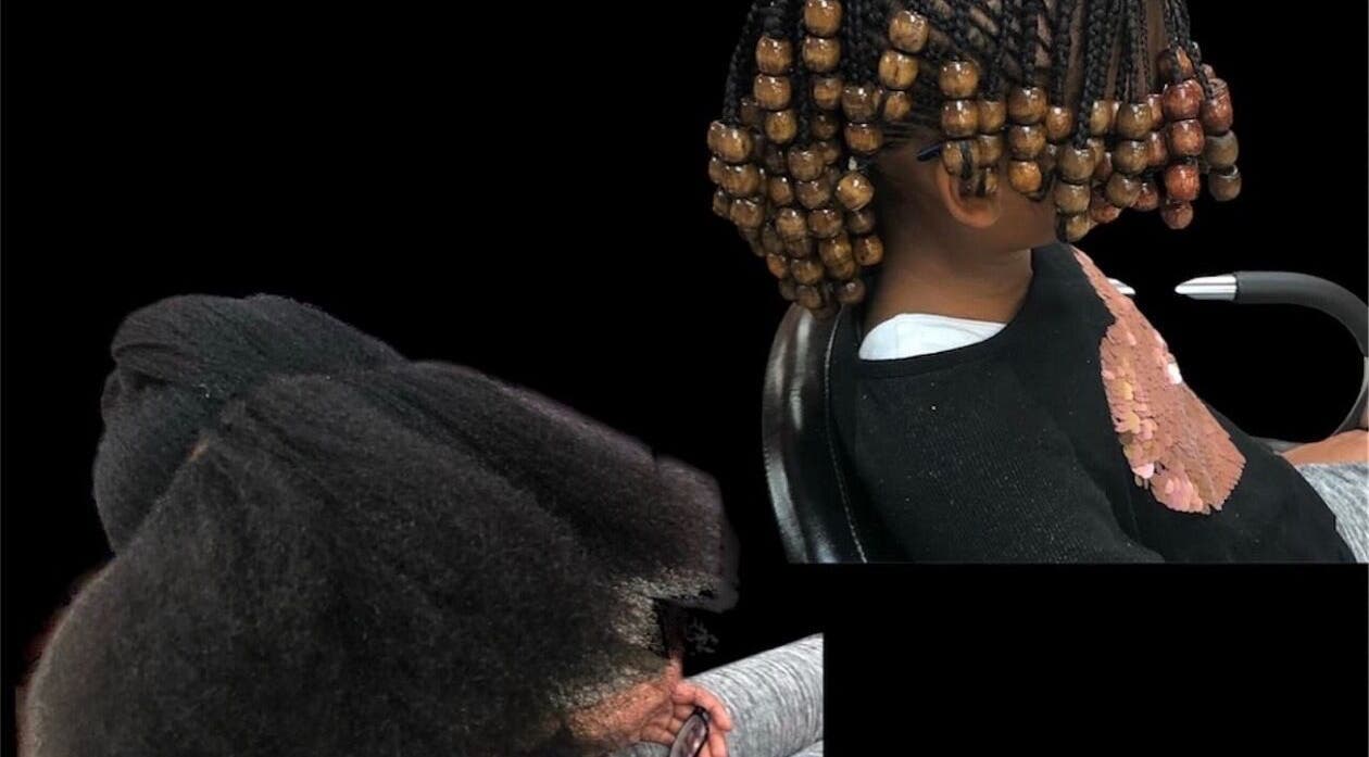 Child with intricate bead-adorned braids at YEREM' salon, Irvington, New Jersey, US.