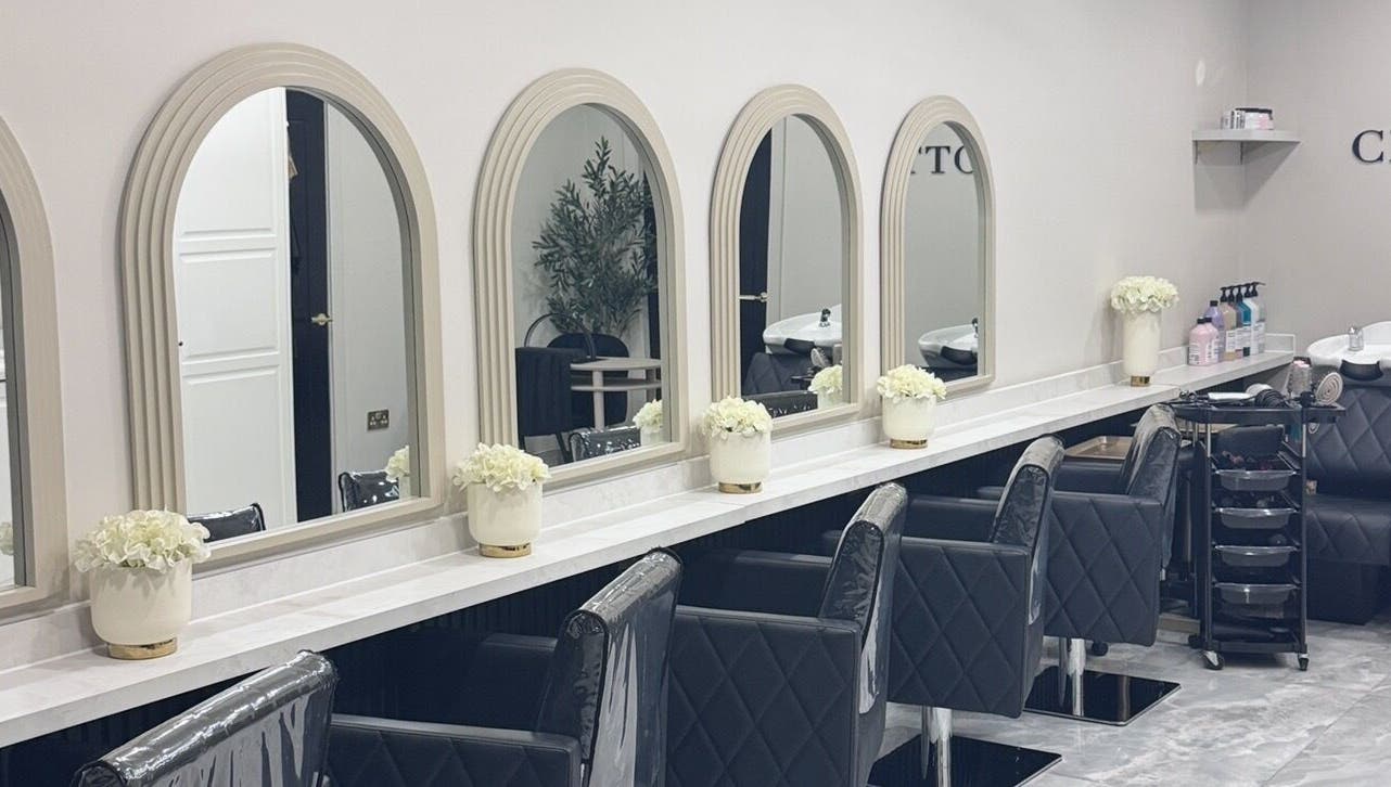 Glossy Studio's elegant salon interior with chic black chairs and large mirrors in Liverpool, England, GB.