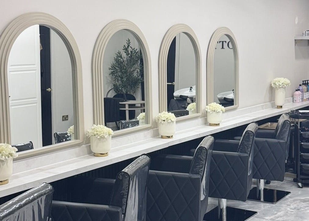 Glossy Studio's elegant salon interior with chic black chairs and large mirrors in Liverpool, England, GB.