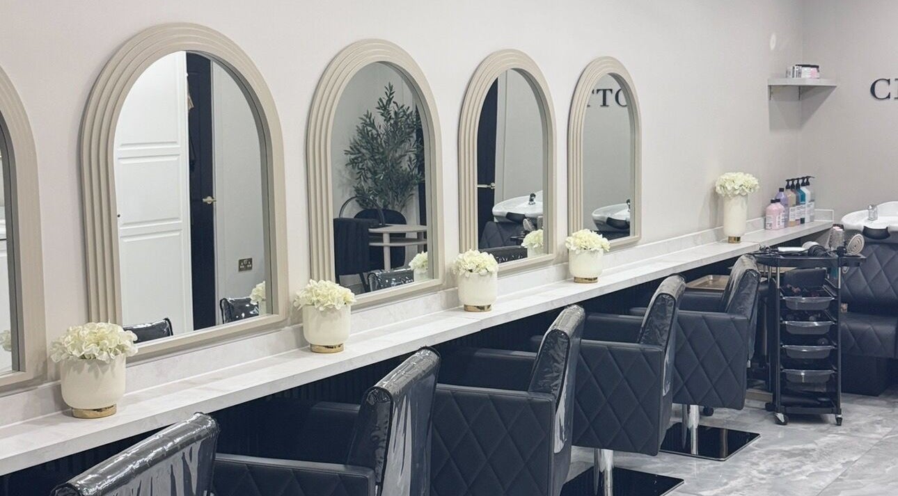 Glossy Studio's elegant salon interior with chic black chairs and large mirrors in Liverpool, England, GB.