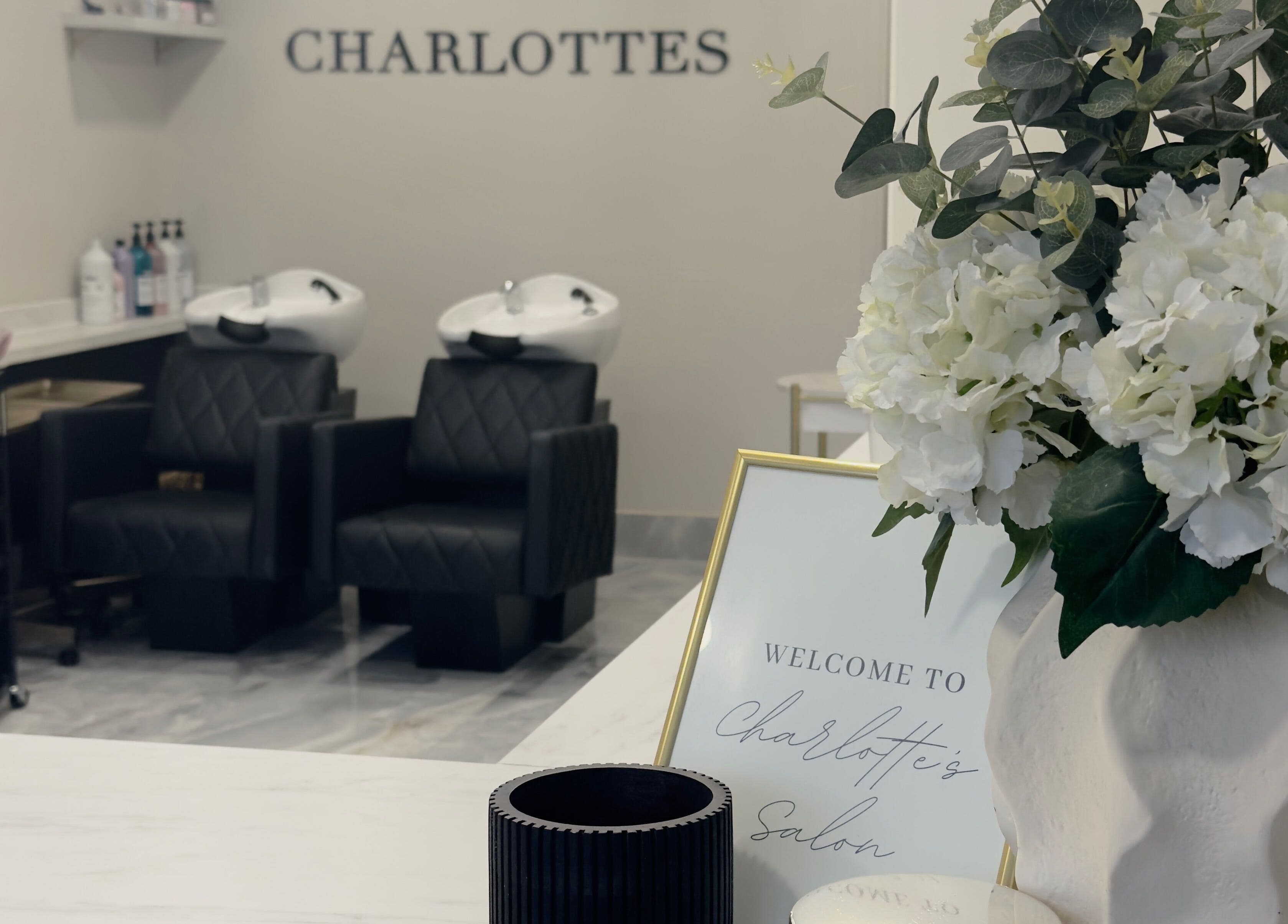 Glossy Studio salon interior with chairs and floral decor, located in Liverpool, England, GB.