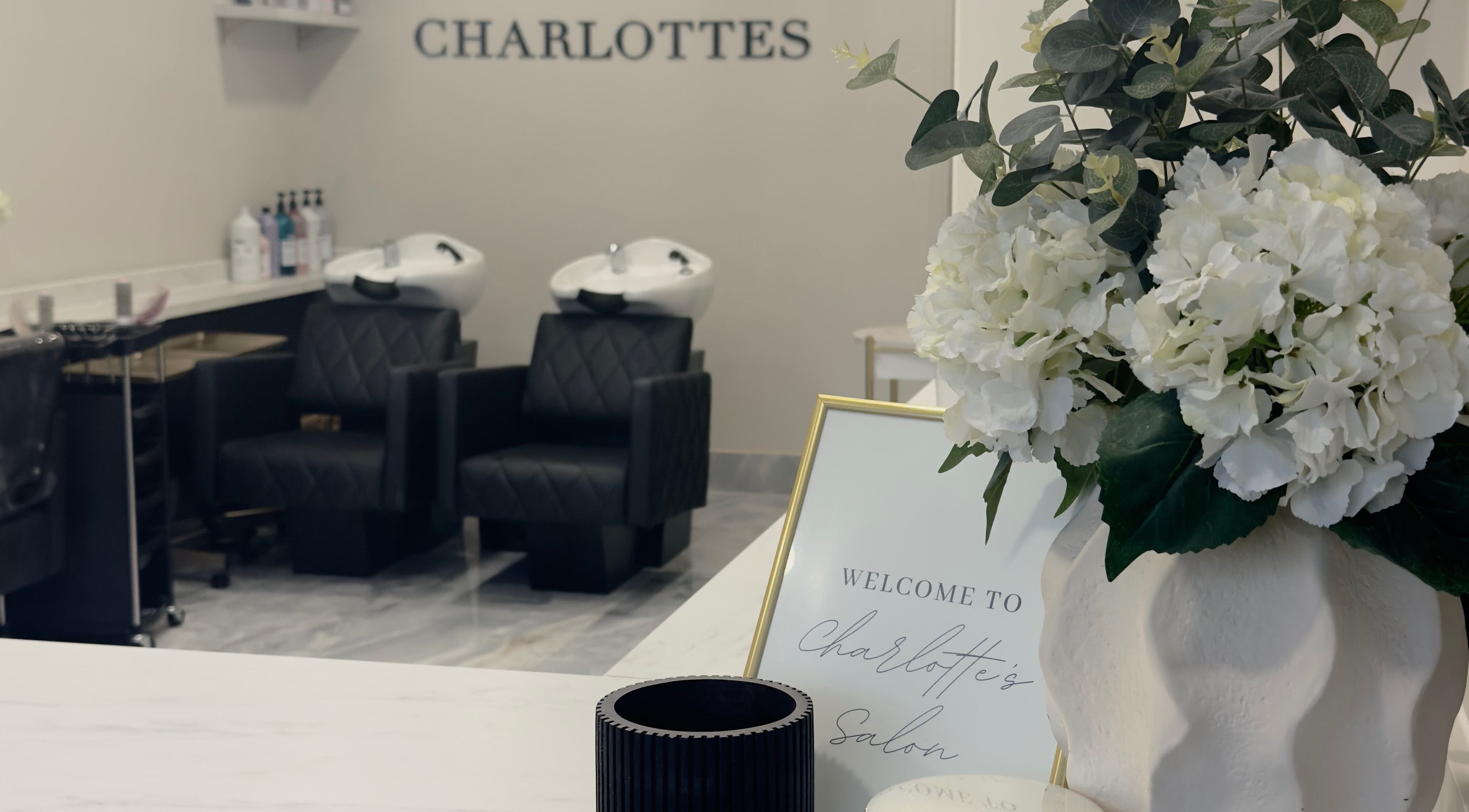 Glossy Studio salon interior with chairs and floral decor, located in Liverpool, England, GB.