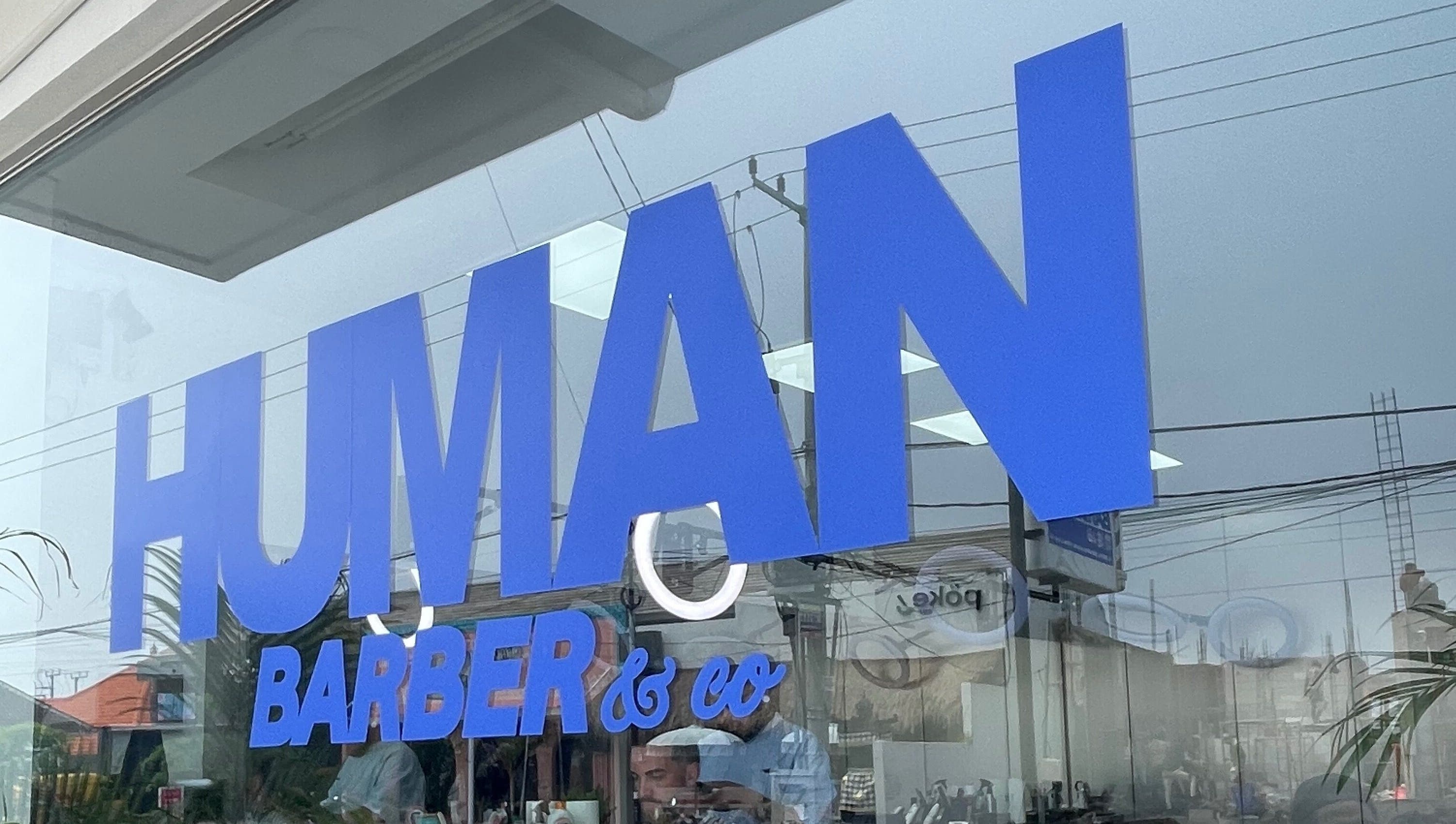 Tampilan depan Human Barber Club VOL 1 di Bali, Bali, ID dengan logo biru cerah.