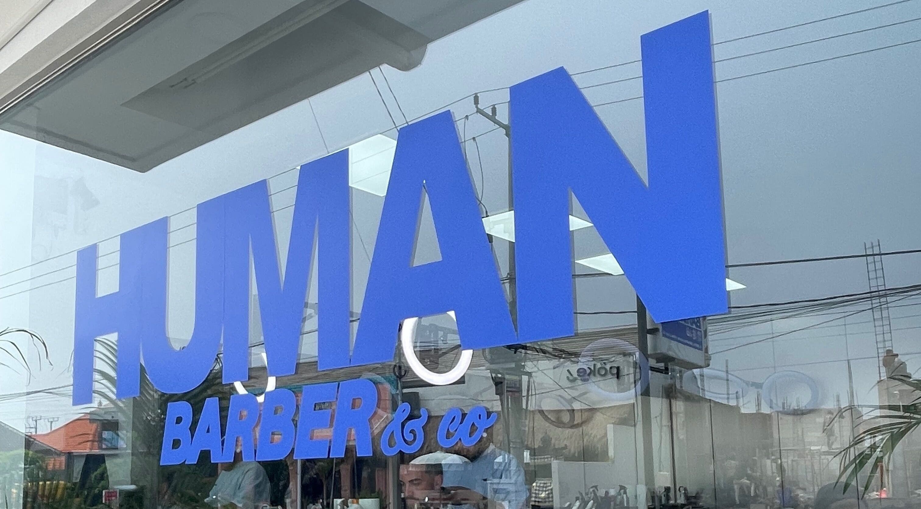 Tampilan depan Human Barber Club VOL 1 di Bali, Bali, ID dengan logo biru cerah.