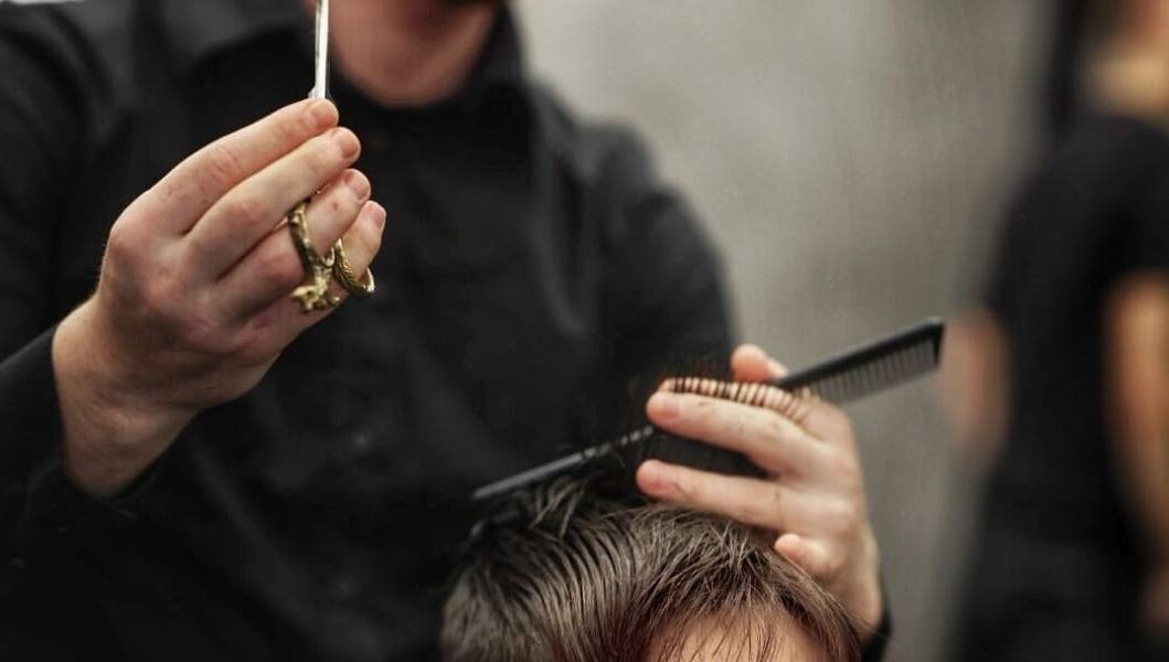 Parrucchiere esegue un taglio di precisione a Salone Dante, Verona, Veneto, IT.