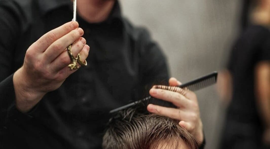 Parrucchiere esegue un taglio di precisione a Salone Dante, Verona, Veneto, IT.
