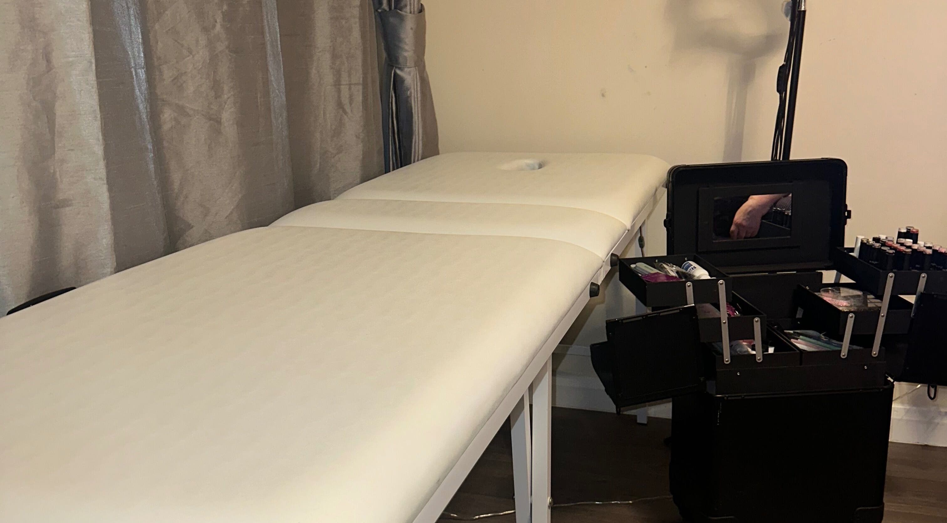 Massage table in GlowLab, Thetford, England, GB with open makeup case nearby.