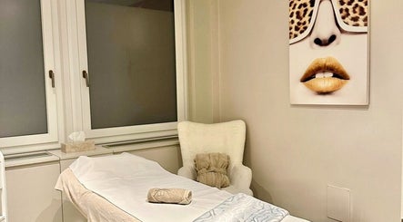 Salle de soins relaxante à DNA Beauty, Genève, Genève, CH avec lit de massage et décoration élégante.