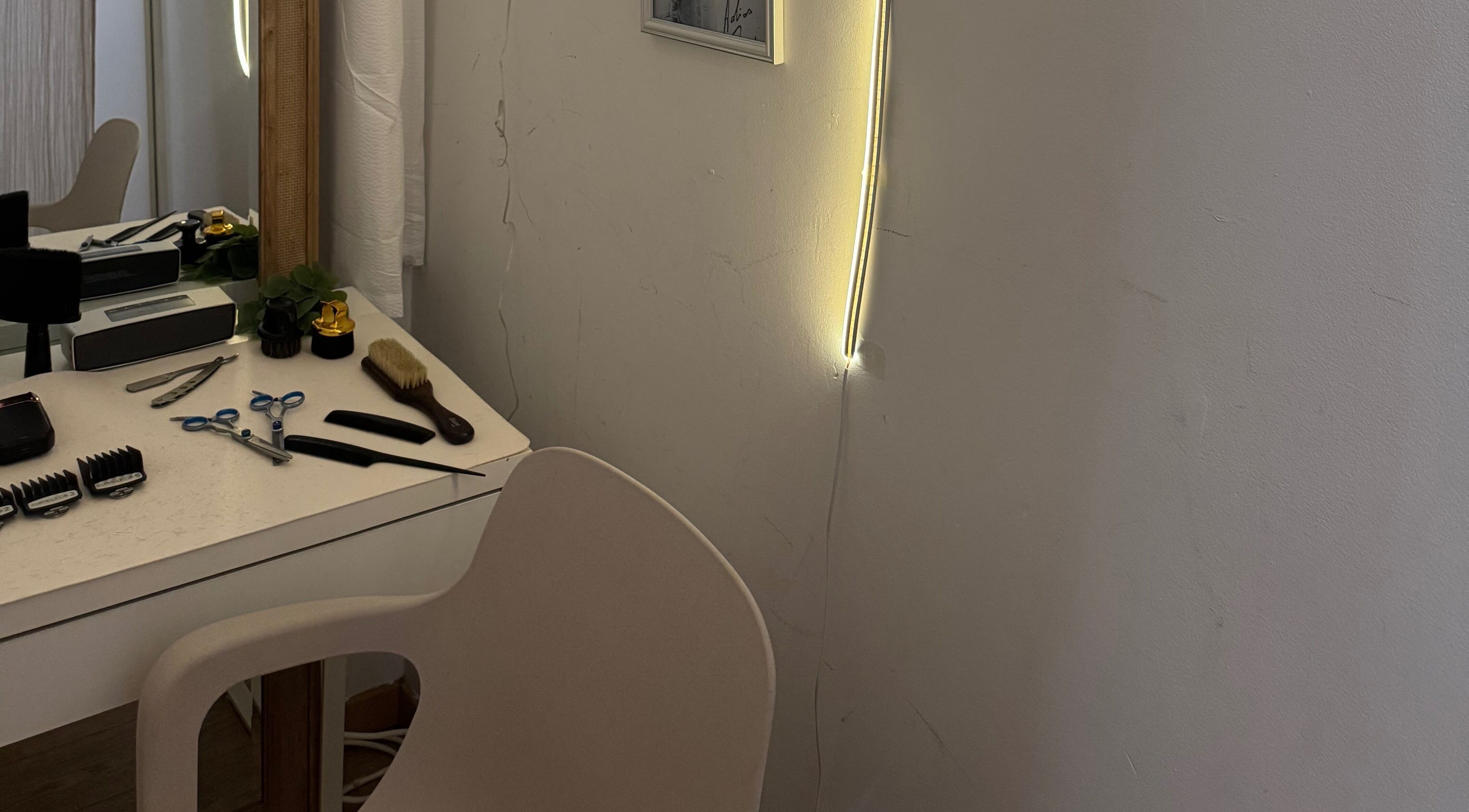 Espace de coiffure élégant de HAIRCUT_HV à Vernier, Genève, CH avec outils professionnels sur une table.