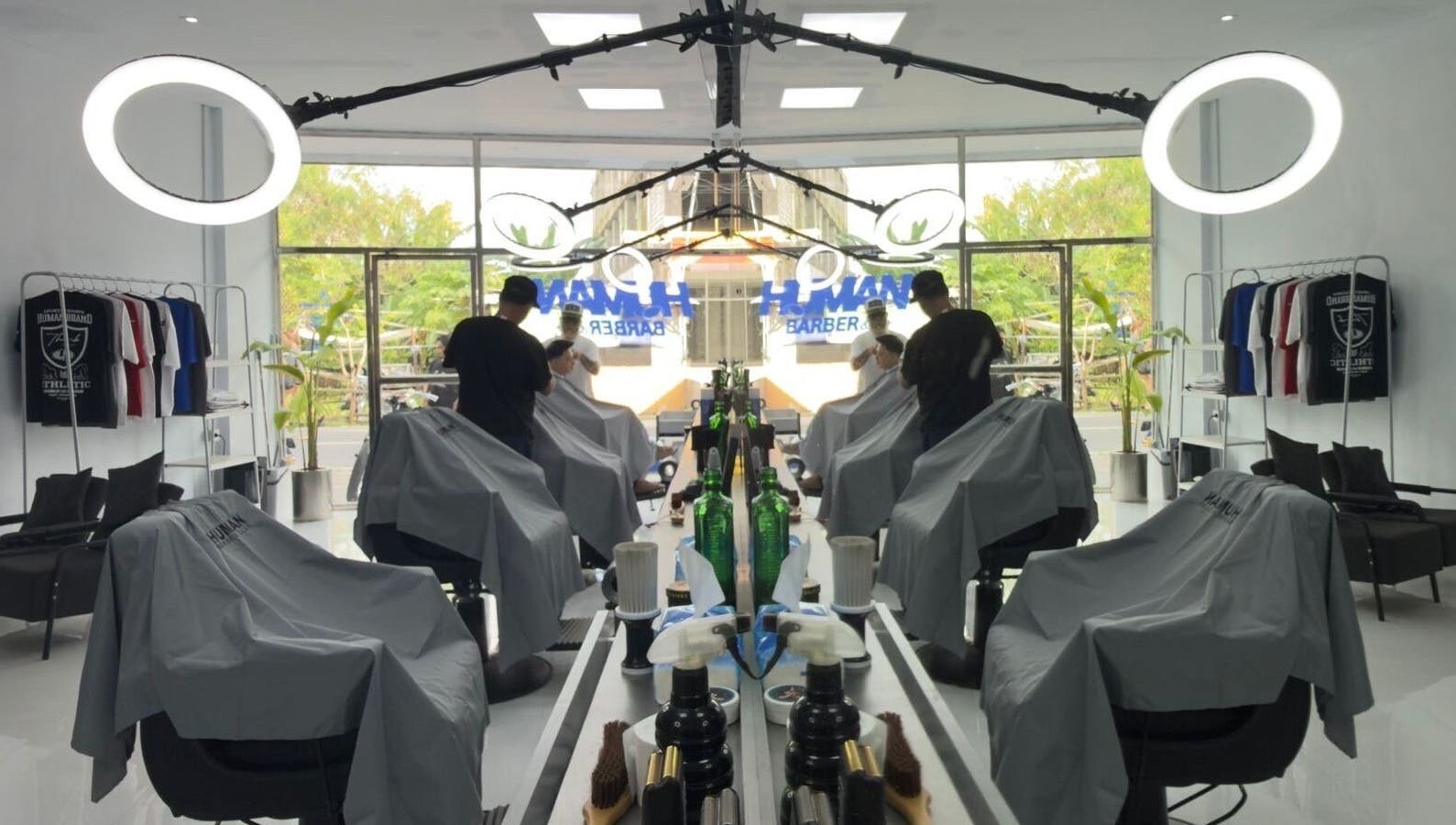 Interior of Human Barber Club Vol 2 in Bali, ID showing modern barber chairs and illuminated mirrors.