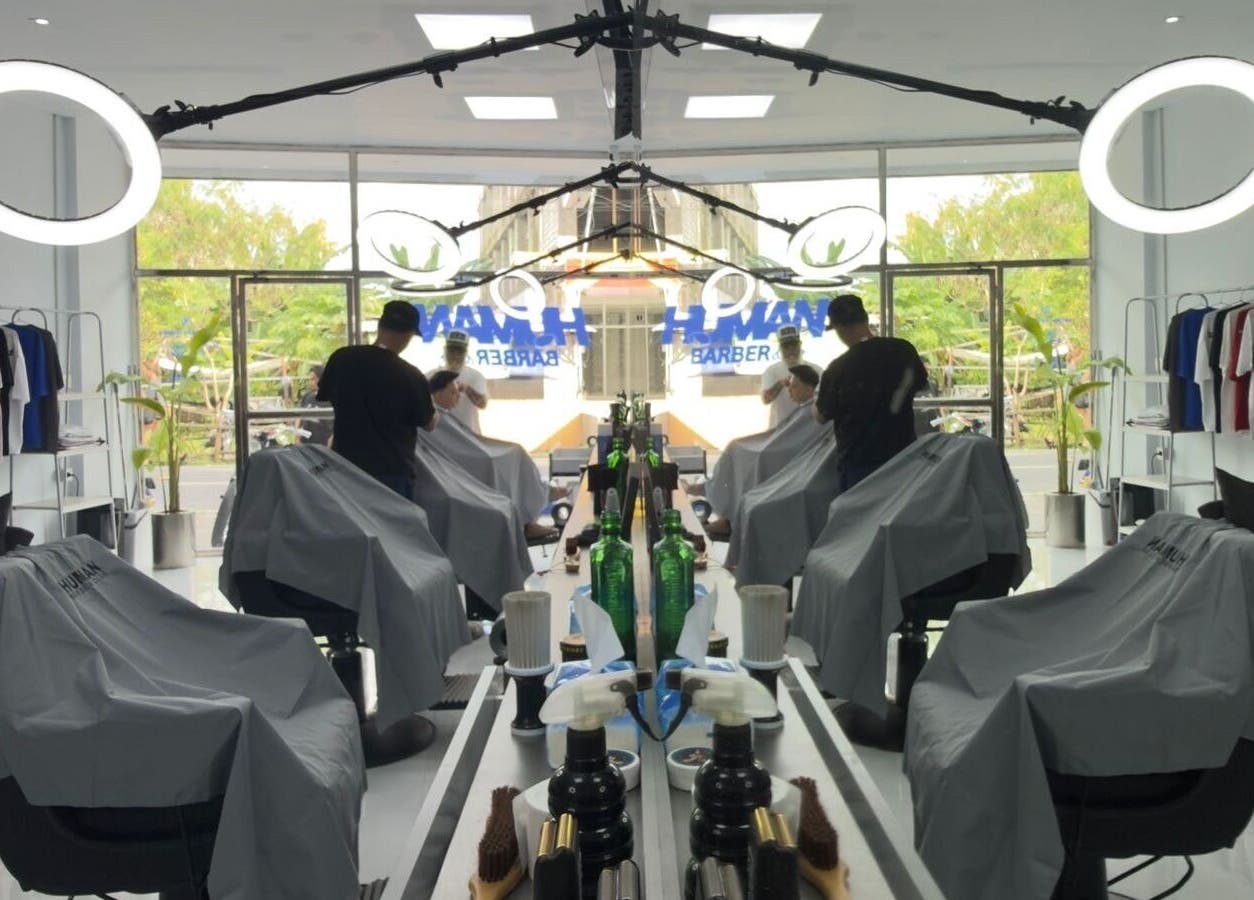 Interior of Human Barber Club Vol 2 in Bali, ID showing modern barber chairs and illuminated mirrors.