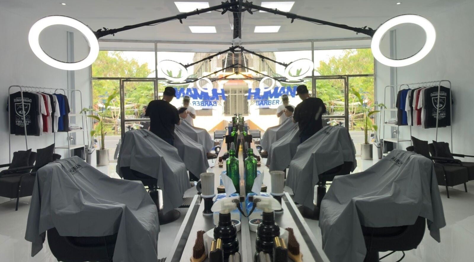 Interior of Human Barber Club Vol 2 in Bali, ID showing modern barber chairs and illuminated mirrors.