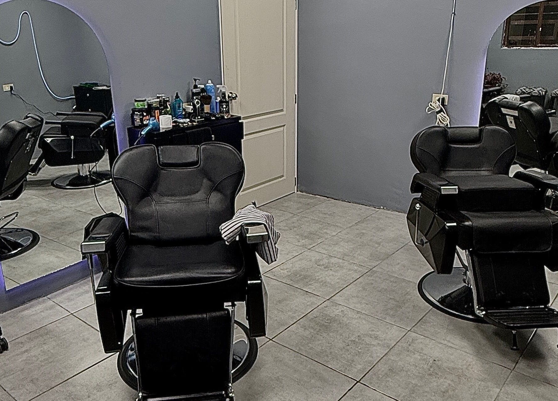 Interior del Mucho Pelo Barber Studio en Juárez, Chihuahua, MX, mostrando sillones de barbería modernos.